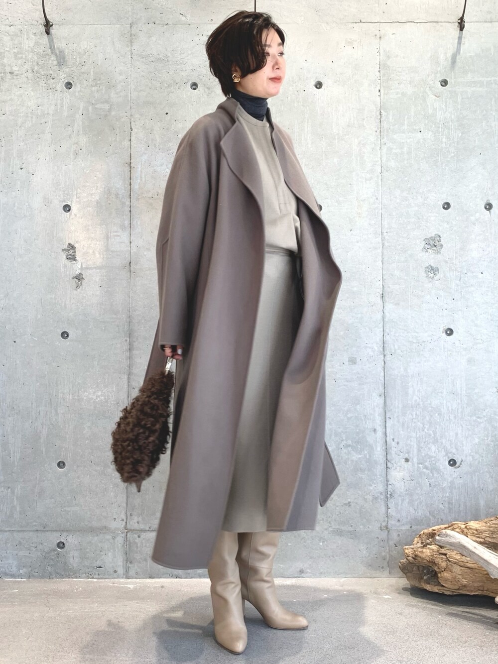 グレー系のニット/セーター、ベージュ系のトップス、ベージュ系のスカートを着用したレディースの秋コーディネートの1枚目の写真