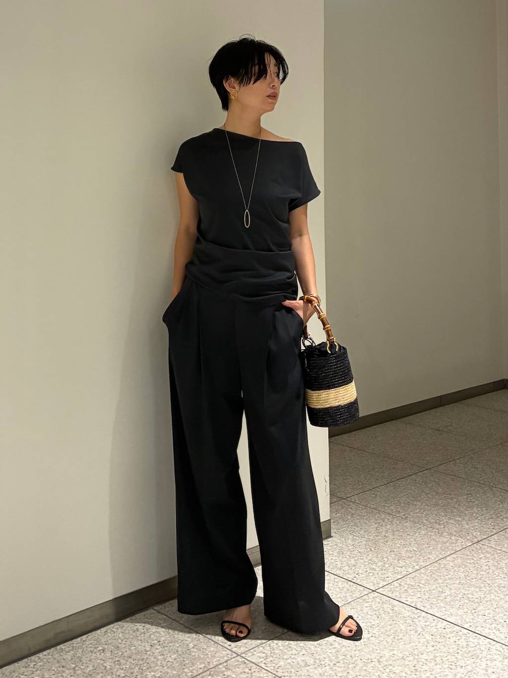 グレー系のその他パンツ、グレー系のTシャツ/カットソー、ベージュ系のハンドバッグを着用したレディースの夏コーディネートの1枚目の写真