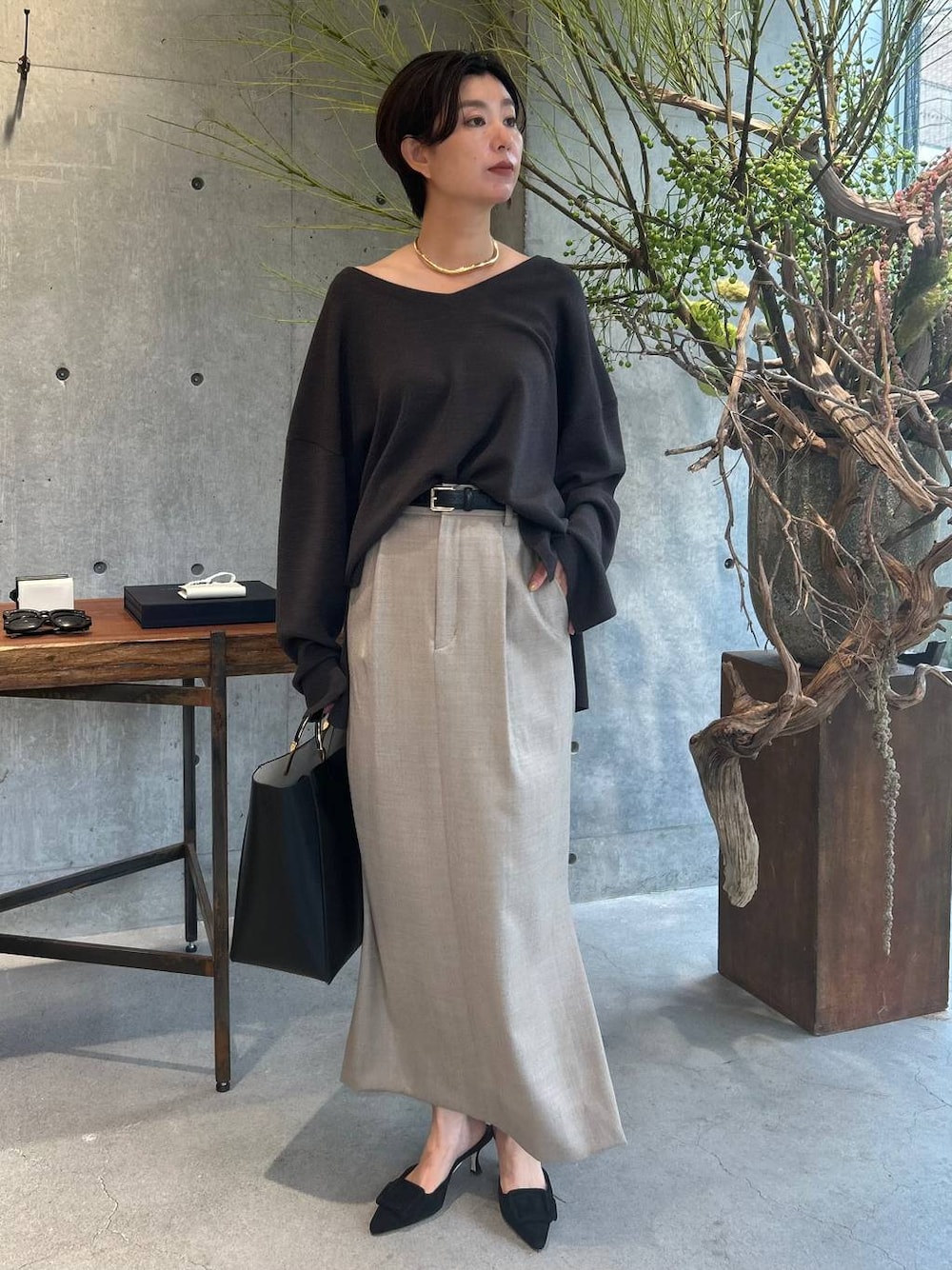 ブラウン系のニット/セーター、ベージュ系のスカート、ベージュ系のスカートを着用したレディースの秋コーディネートの1枚目の写真