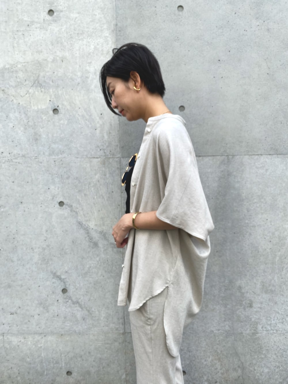 ベージュ系のシャツ/ブラウス、ベージュ系のスラックス、ブラック系のタンクトップを着用したレディースの春コーディネートの4枚目の写真