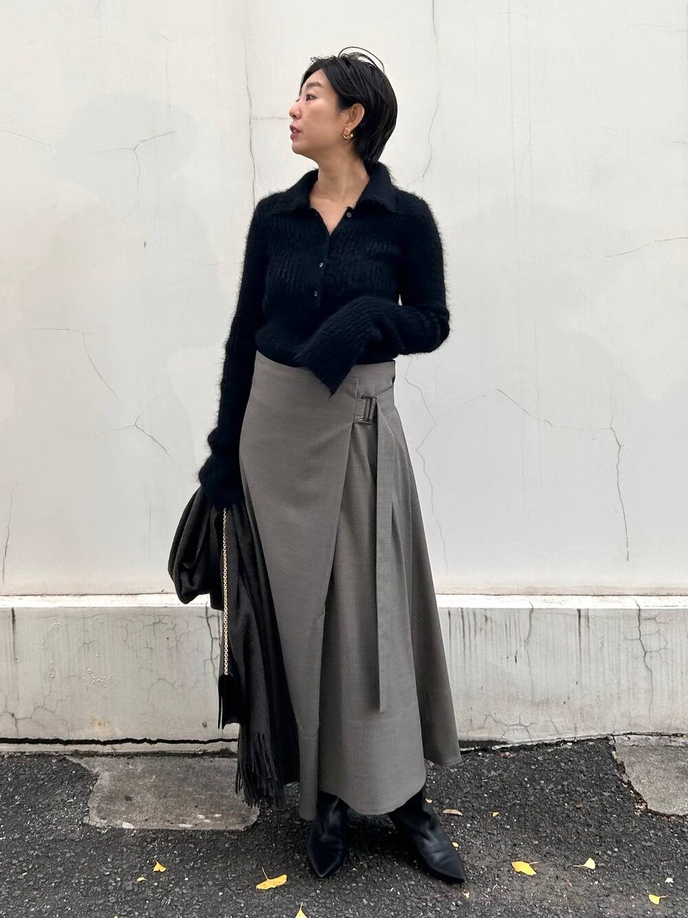 ブラック系のニット/セーター、ベージュ系のスカート、ブラウン系のストール/ショールを着用したレディースの冬コーディネートの1枚目の写真