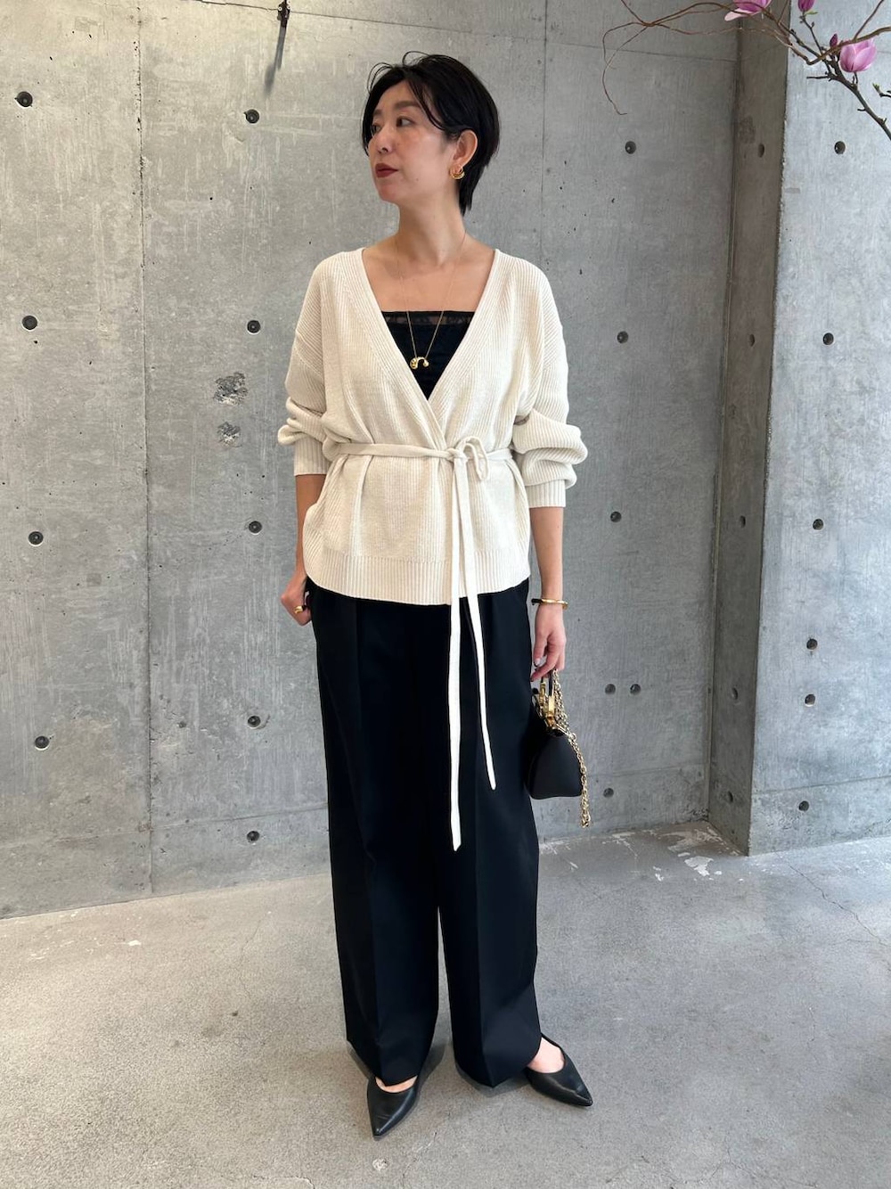 ブラック系のその他トップス、ホワイト系のカーディガン/ボレロ、ブラック系のスラックスを着用したレディースの冬コーディネートの1枚目の写真