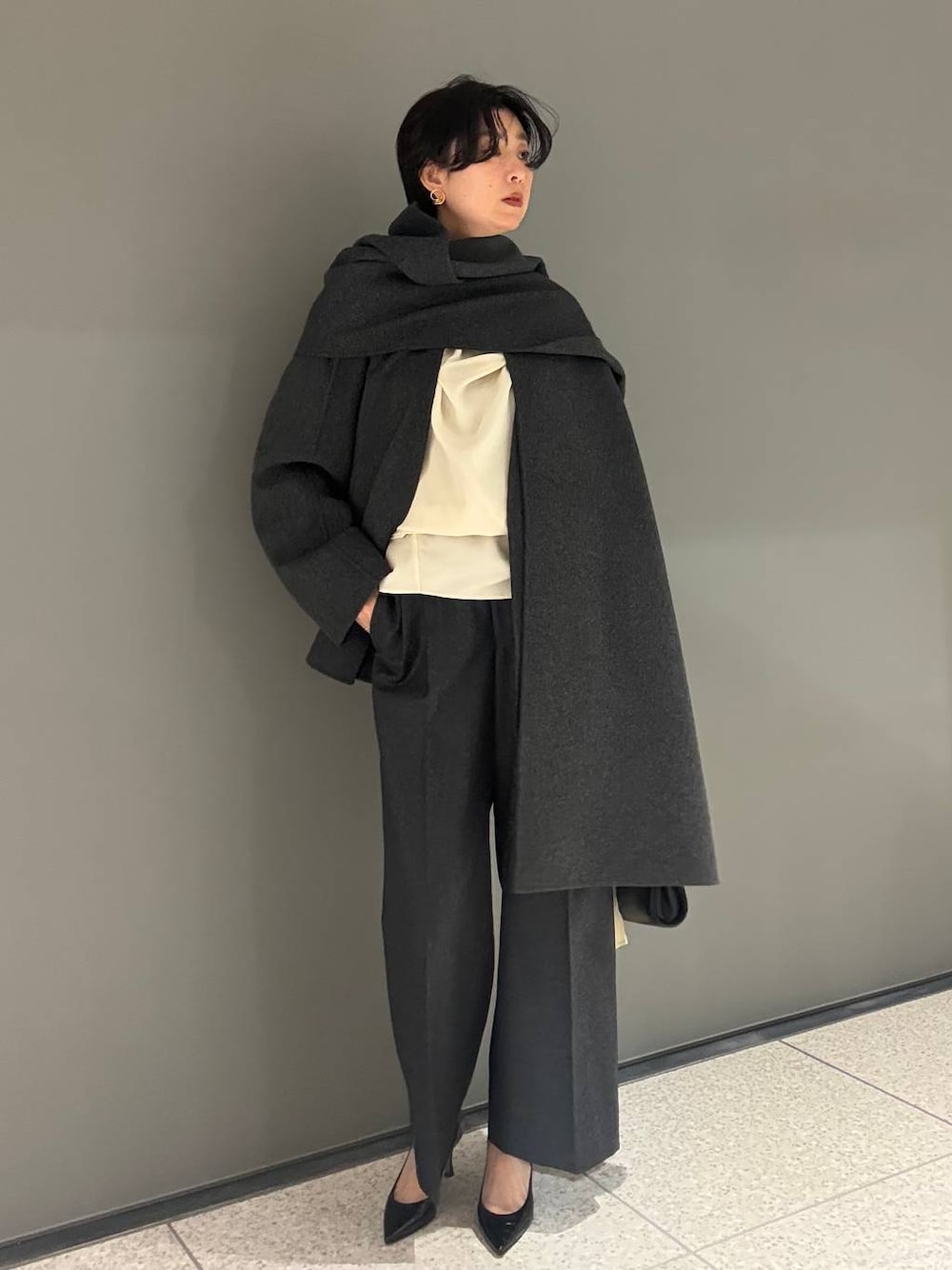 グレー系のその他アウター、グレー系のスラックスを着用したレディースの秋コーディネートの1枚目の写真
