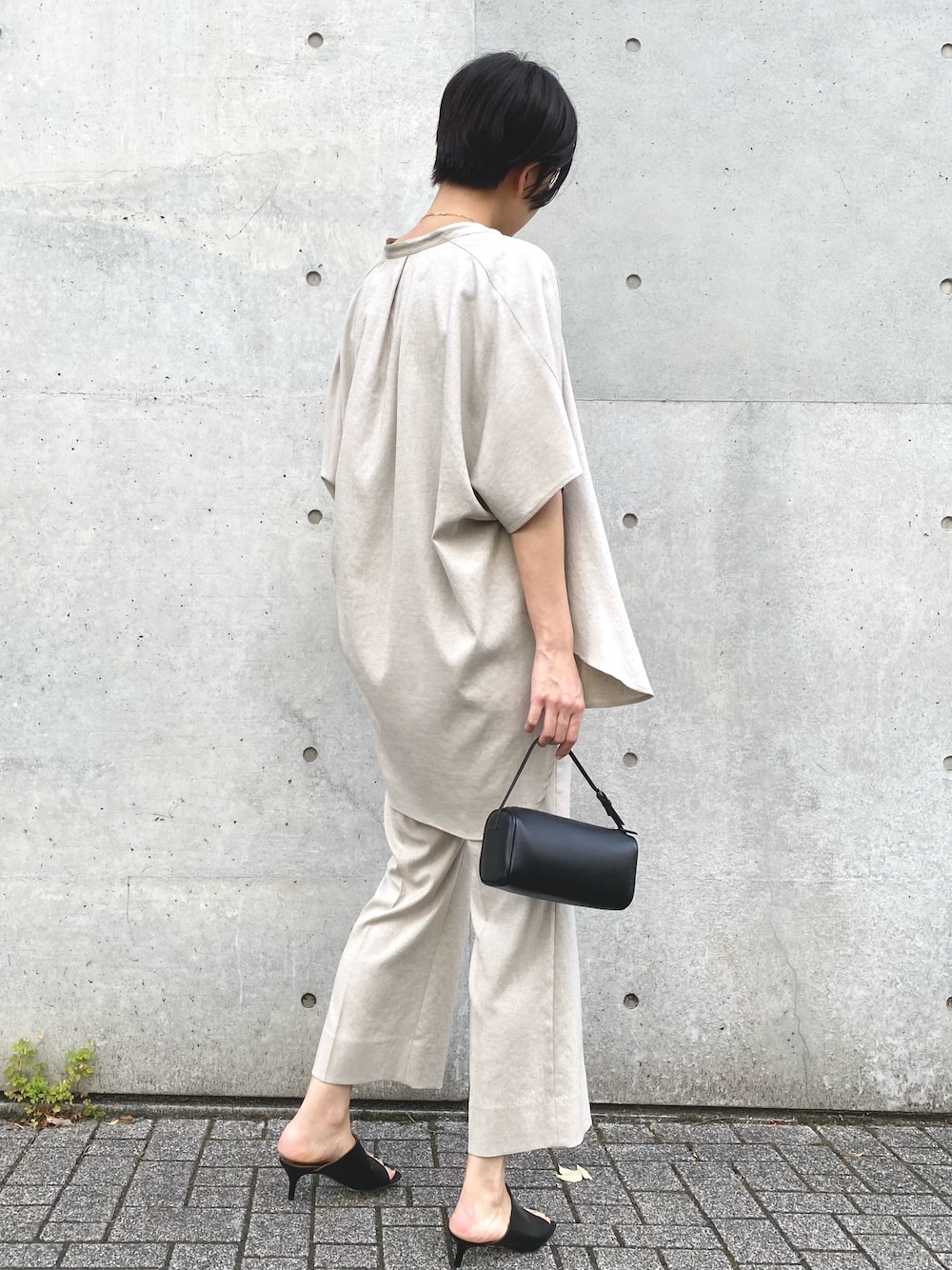 ベージュ系のシャツ/ブラウス、ベージュ系のスラックス、ブラック系のタンクトップを着用したレディースの春コーディネートの3枚目の写真