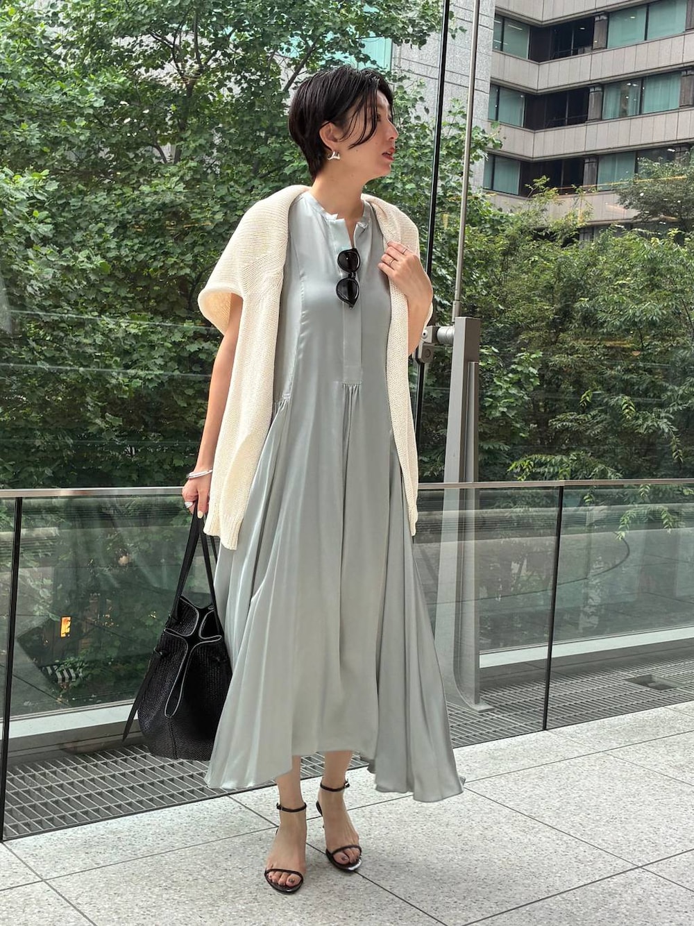 グリーン系のワンピース、グレー系のタンクトップ、ホワイト系のニット/セーターを着用したレディースの夏コーディネートの1枚目の写真