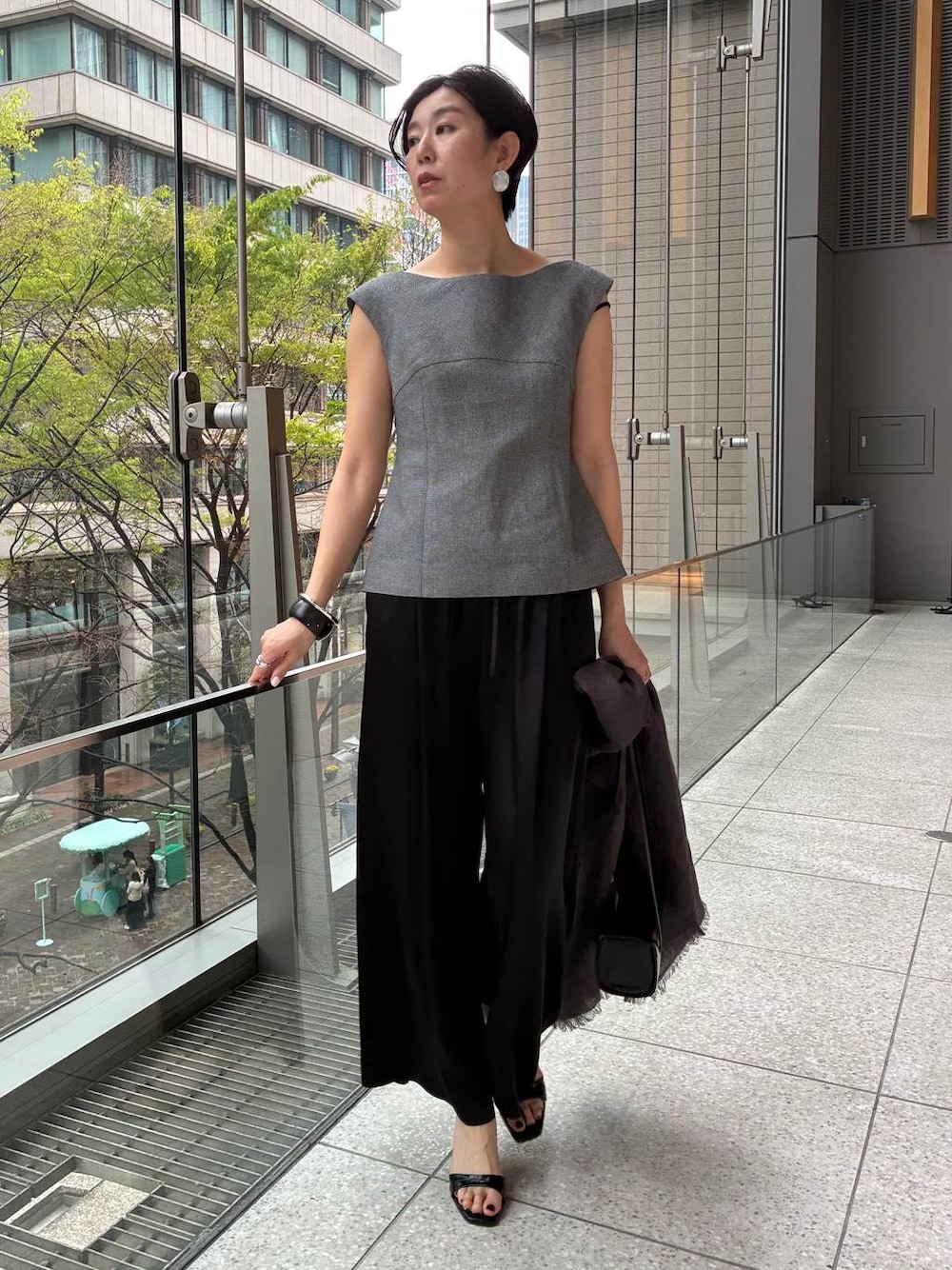 ブラック系のその他パンツ、ホワイト系のその他トップス、ブラウン系のストール/ショールを着用したレディースの春コーディネートの1枚目の写真