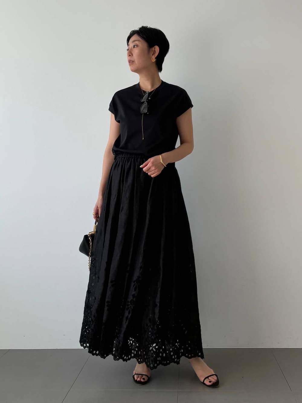 ブラック系のTシャツ/カットソー、ブラック系のスカートを着用したレディースの春コーディネートの1枚目の写真
