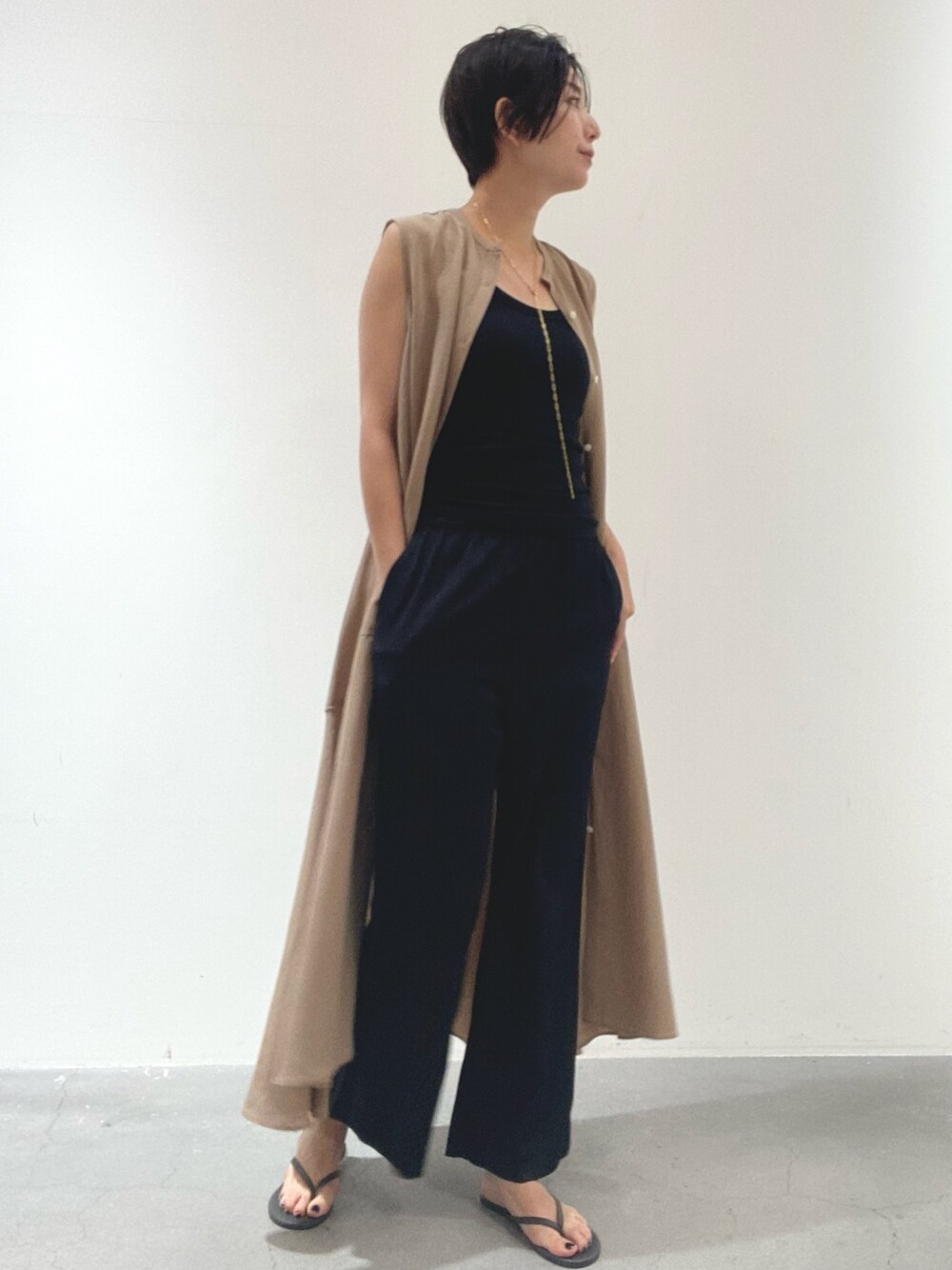 イエロー系のワンピース、ブラック系のタンクトップ、ブラック系のその他パンツを着用したレディースの夏コーディネートの1枚目の写真