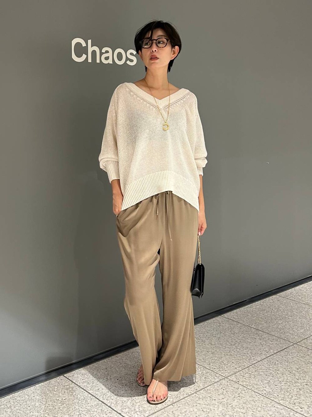 ベージュ系のその他パンツ、ホワイト系のニット/セーターを着用したレディースの夏コーディネートの1枚目の写真
