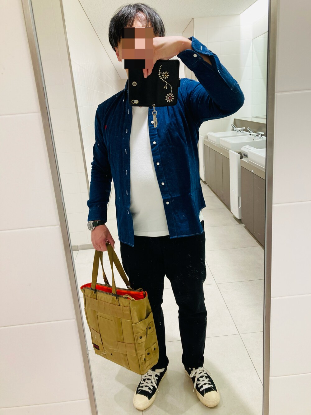 ブラック系のパンツ、ベージュ系のトートバッグ、ブラック系のスニーカーを着用したメンズの秋コーディネートの1枚目の写真