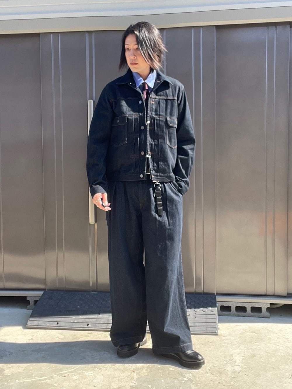 ブルー系のデニムジャケット、ブルー系のデニムパンツ、ブラック系のドレスシューズを着用したメンズの秋コーディネートの1枚目の写真