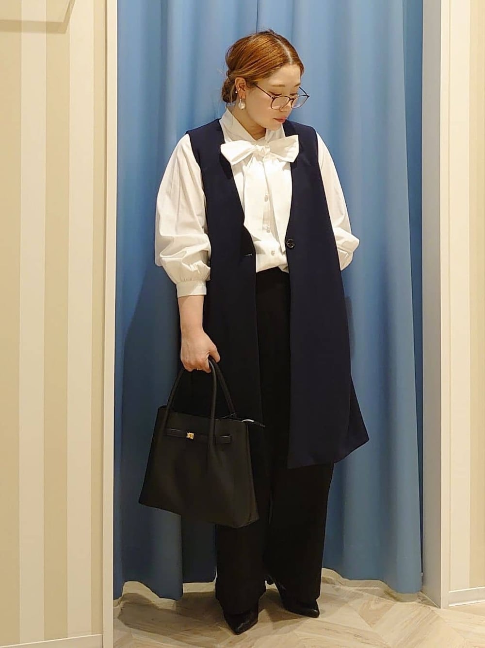 ブルー系のベスト、ホワイト系のシャツ/ブラウス、ブラック系のその他パンツを着用したレディースの冬コーディネートの1枚目の写真