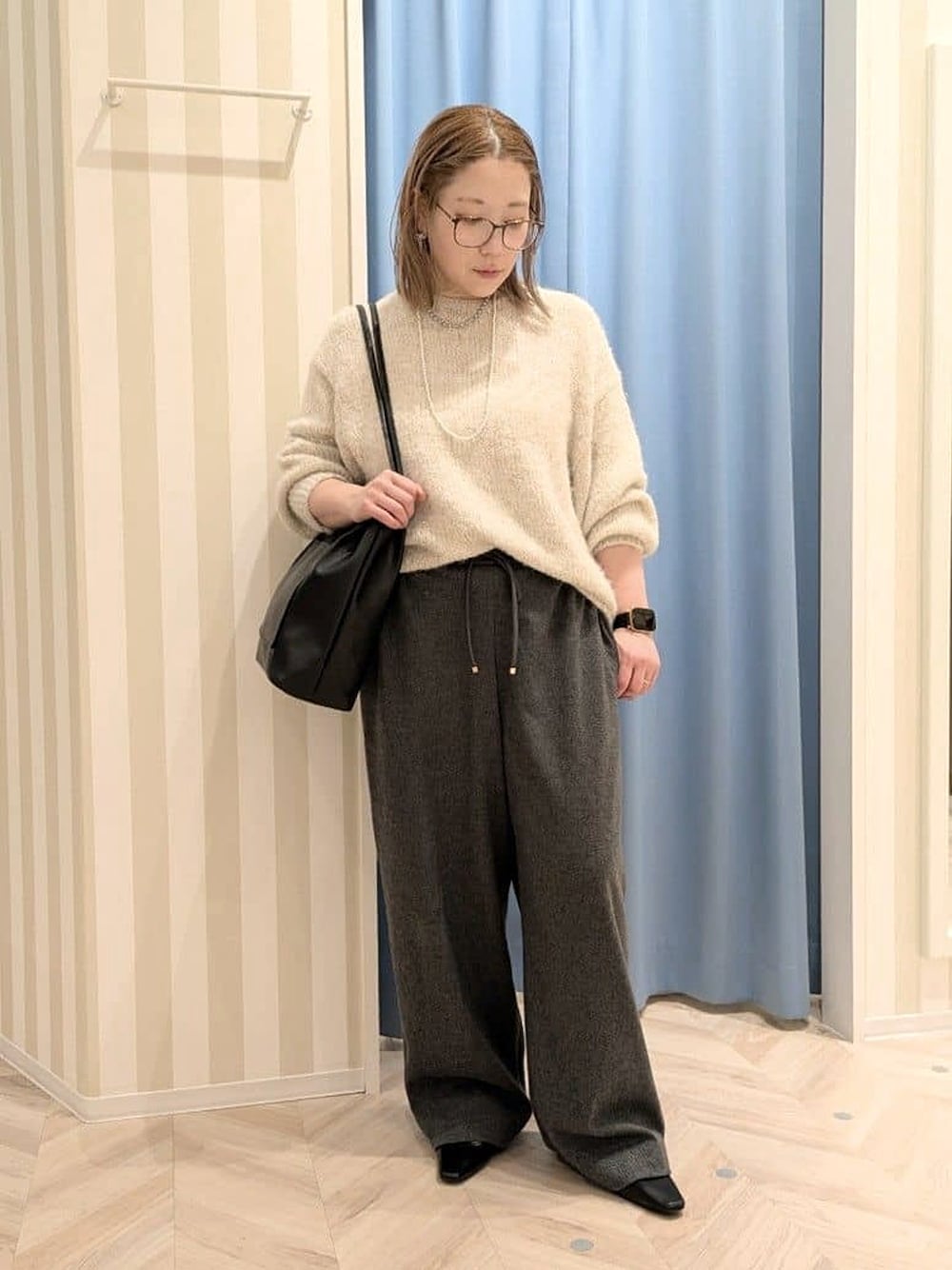 ホワイト系のニット/セーター、ブラック系のその他パンツ、ブラック系のトートバッグを着用したレディースの冬コーディネートの1枚目の写真