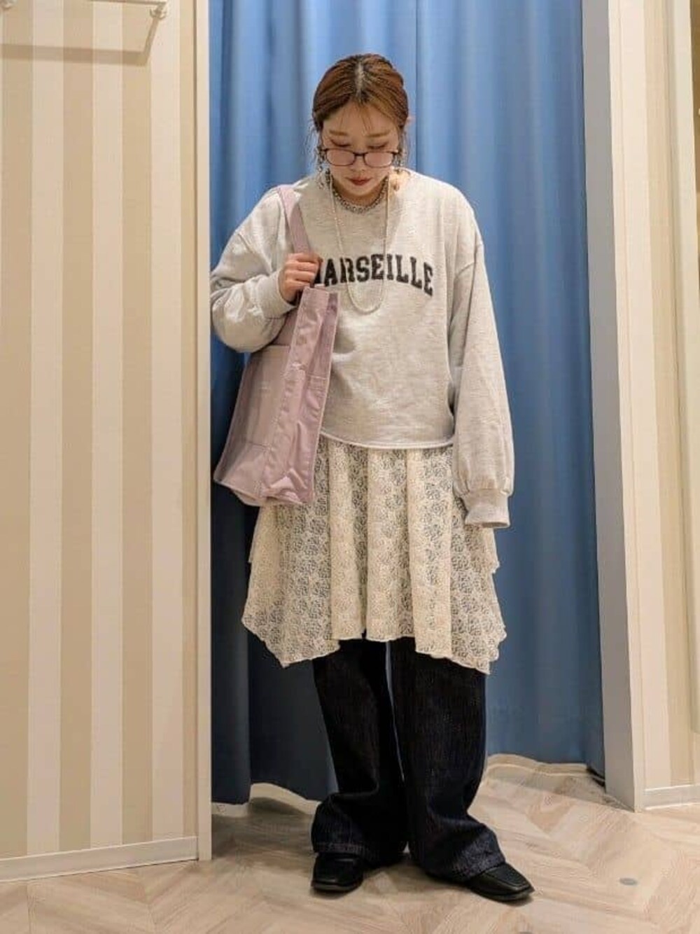 グレー系のスウェット、ホワイト系のチュニック、ブルー系のデニムパンツを着用したレディースの冬コーディネートの1枚目の写真