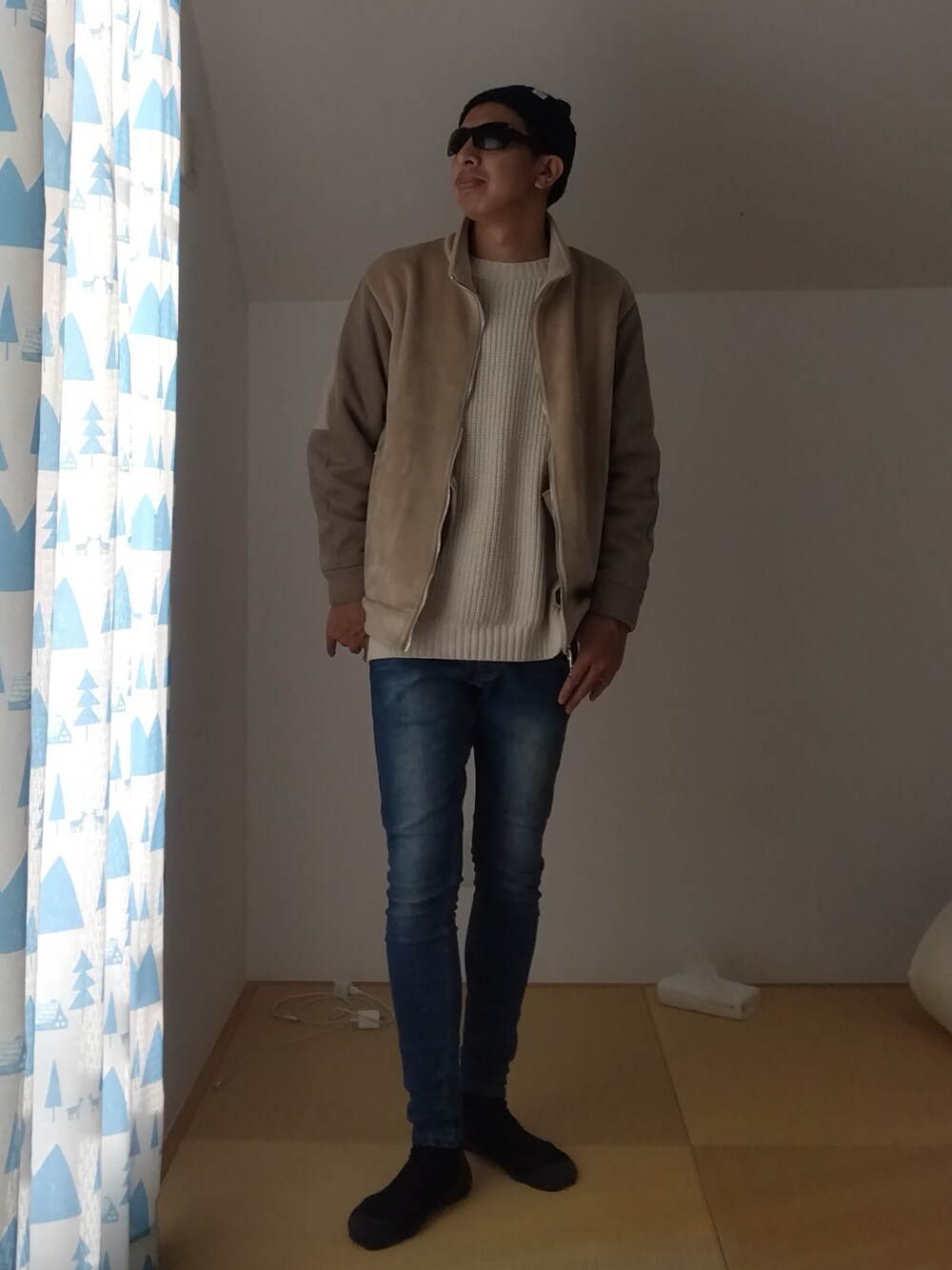 ベージュ系のブルゾン、ベージュ系のニット/セーター、ブルー系のデニムパンツを着用したメンズの冬コーディネートの1枚目の写真
