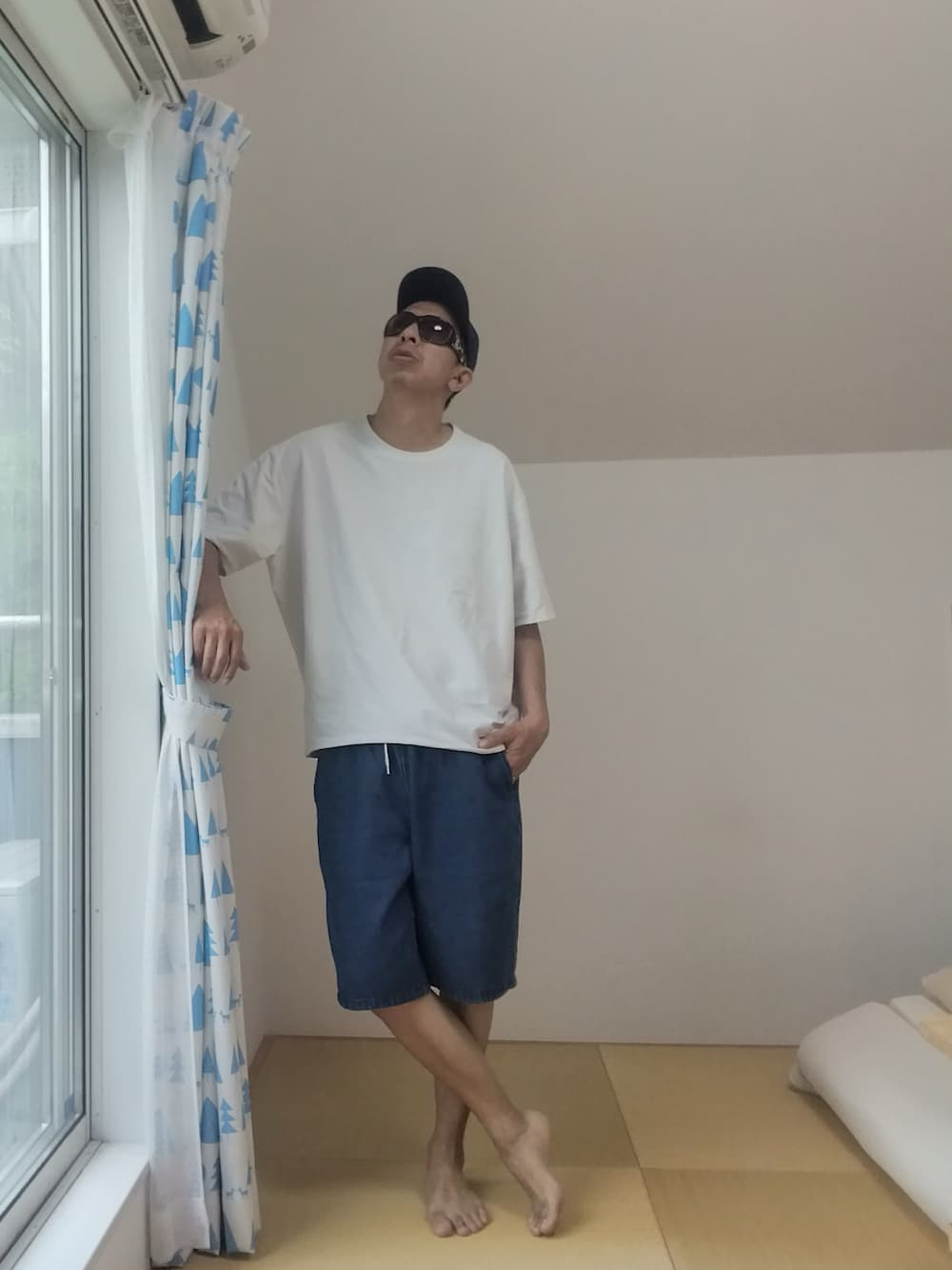 ホワイト系のTシャツ/カットソー、ブルー系のデニムパンツ、ブルー系のキャップを着用したメンズの夏コーディネートの1枚目の写真