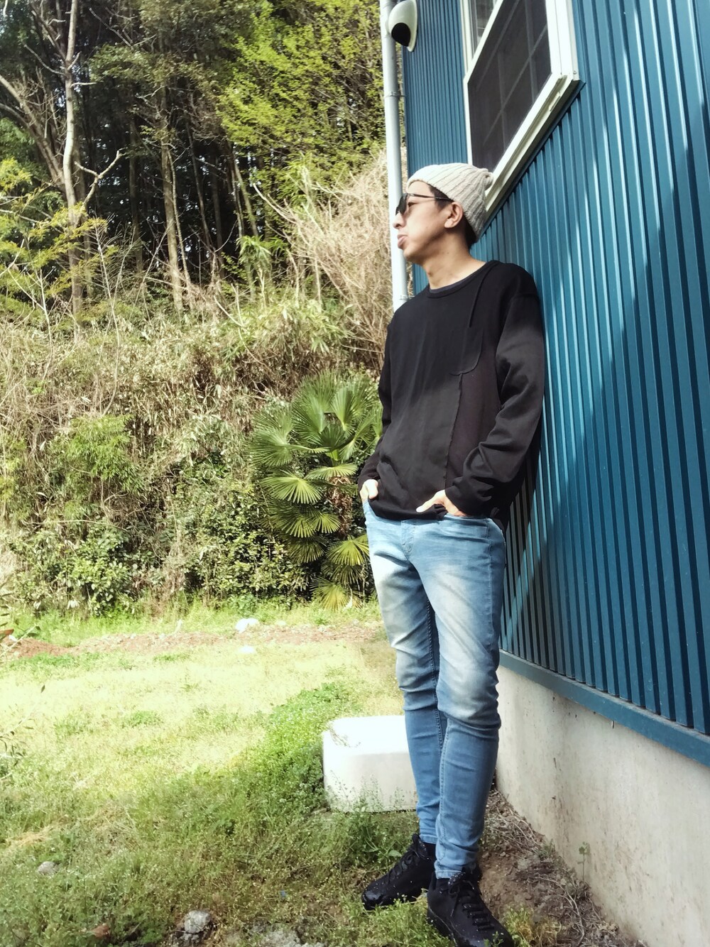 ブラック系のTシャツ/カットソー、ブルー系のデニムパンツ、ブラック系のスニーカーを着用したメンズの春コーディネートの1枚目の写真