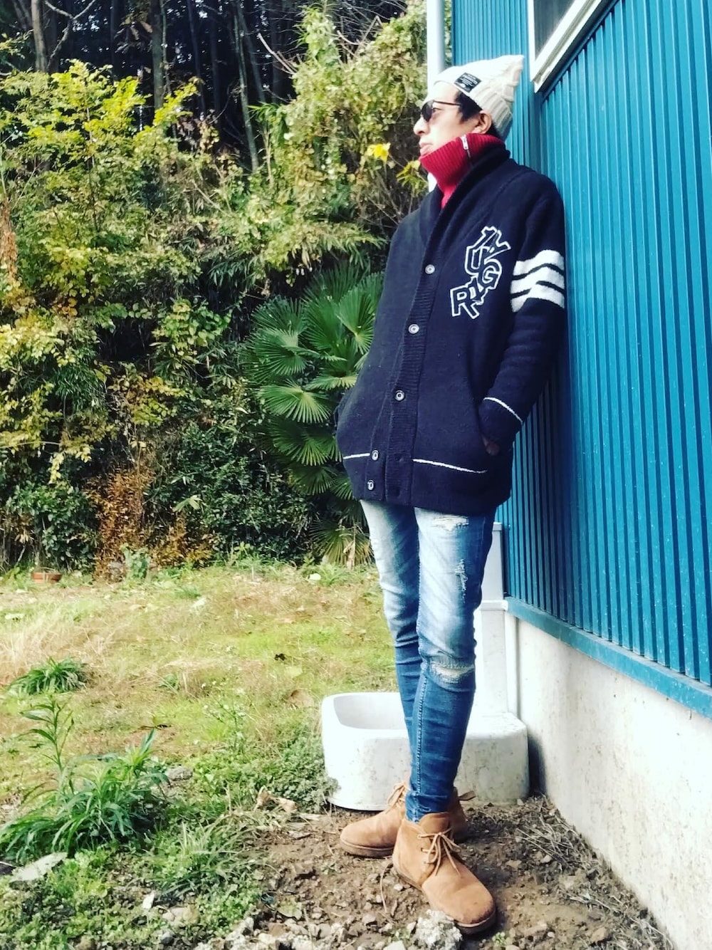 ブラック系のカーディガン/ボレロ、ブルー系のデニムパンツ、ブラウン系のブーツを着用したメンズの冬コーディネートの1枚目の写真