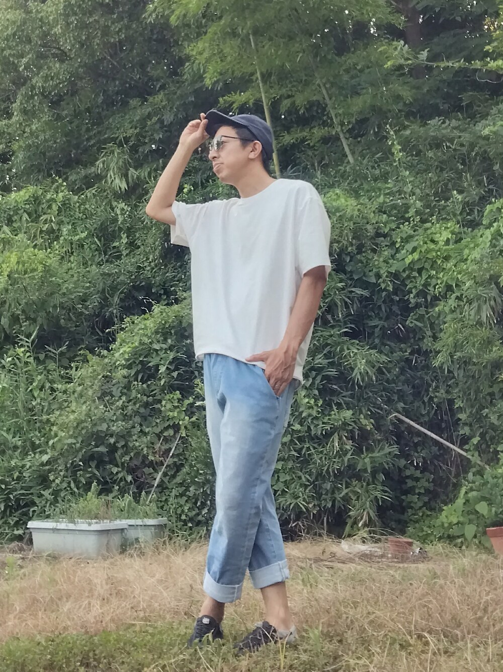 ホワイト系のTシャツ/カットソー、ブルー系のデニムパンツ、ブラック系のサンダルを着用したメンズの夏コーディネートの1枚目の写真