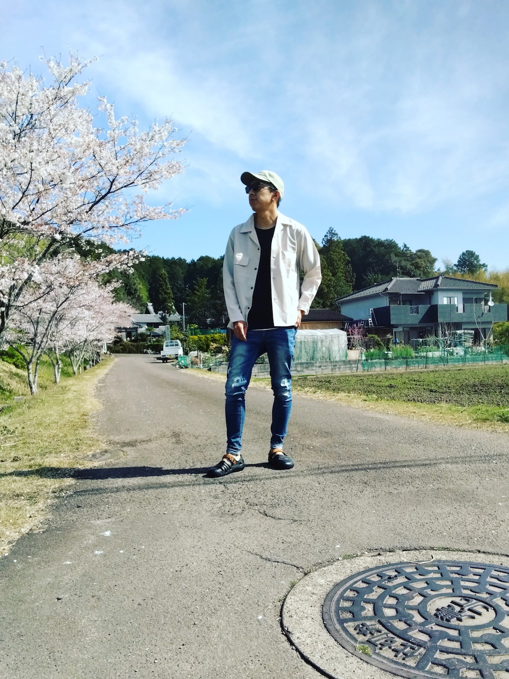 ブルー系のデニムパンツ、ブラック系のサンダル、ベージュ系のシャツ/ブラウスを着用したメンズの春コーディネートの1枚目の写真