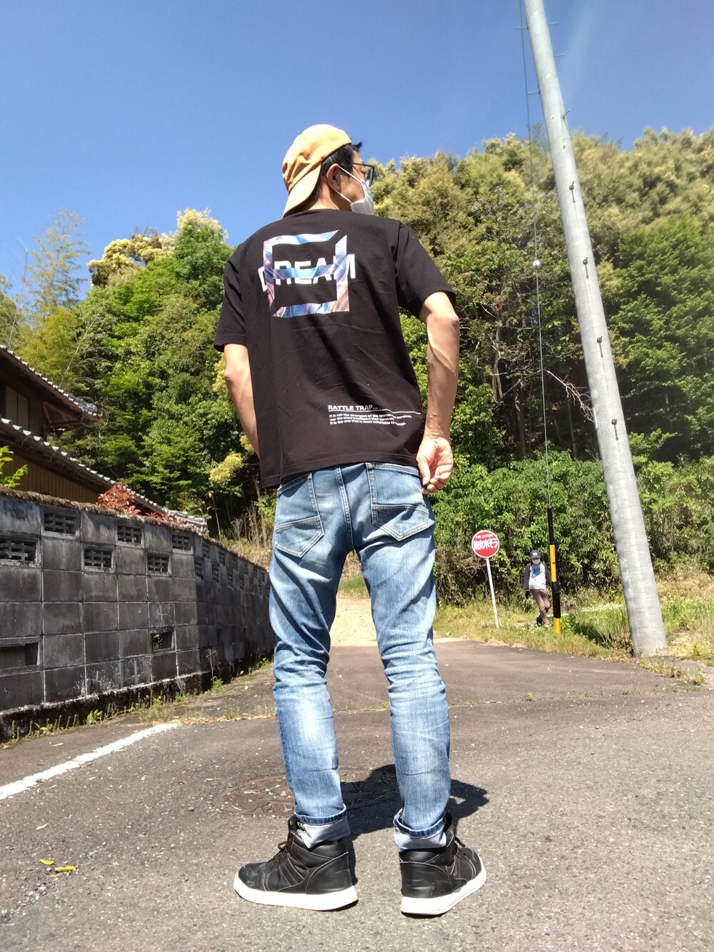 ブラック系のTシャツ/カットソー、ブルー系のデニムパンツ、ブラック系のスニーカーを着用したメンズの春コーディネートの1枚目の写真