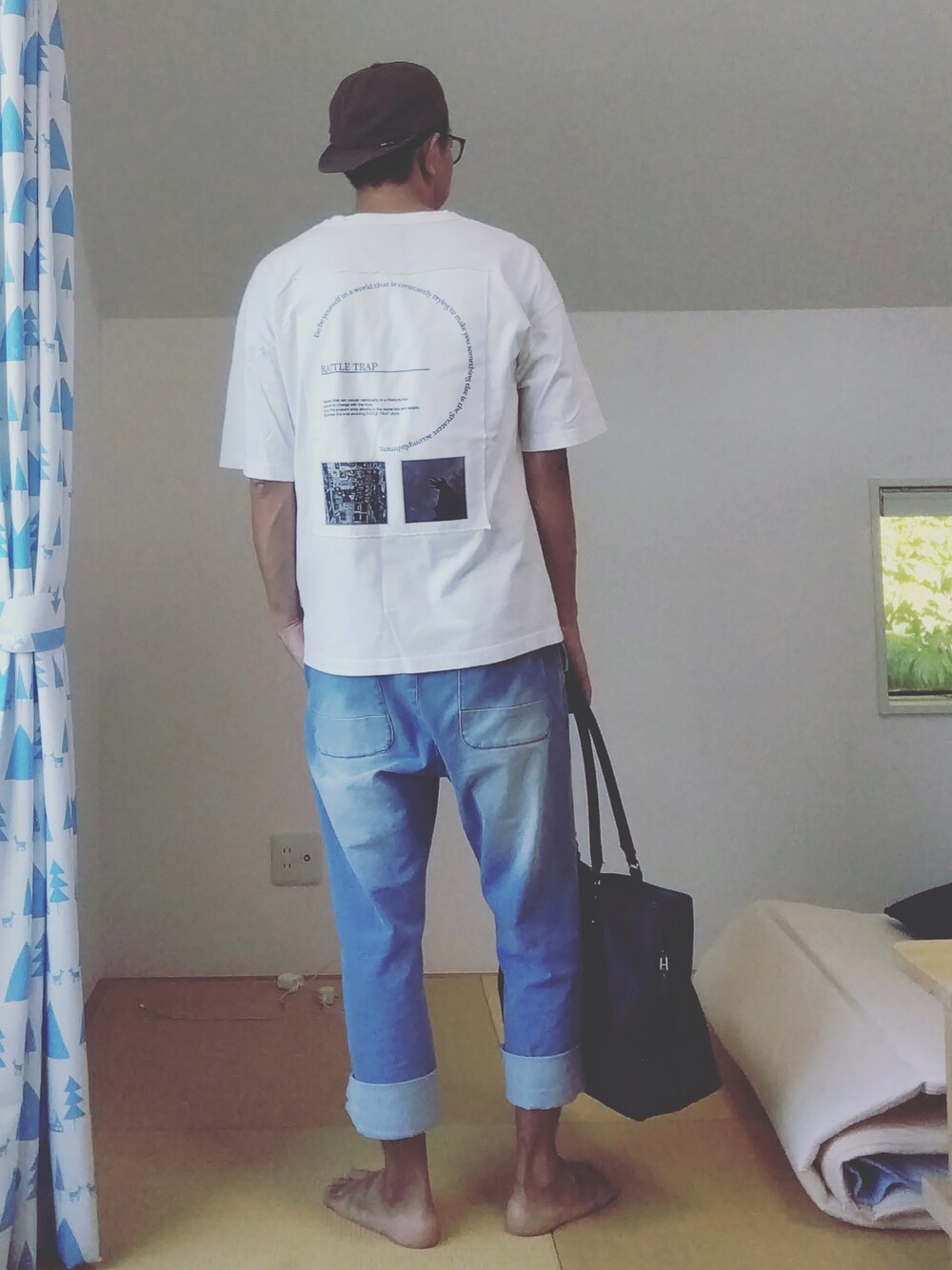 ブルー系のデニムパンツ、ブラック系のトートバッグ、ホワイト系のTシャツ/カットソーを着用したメンズの夏コーディネートの1枚目の写真