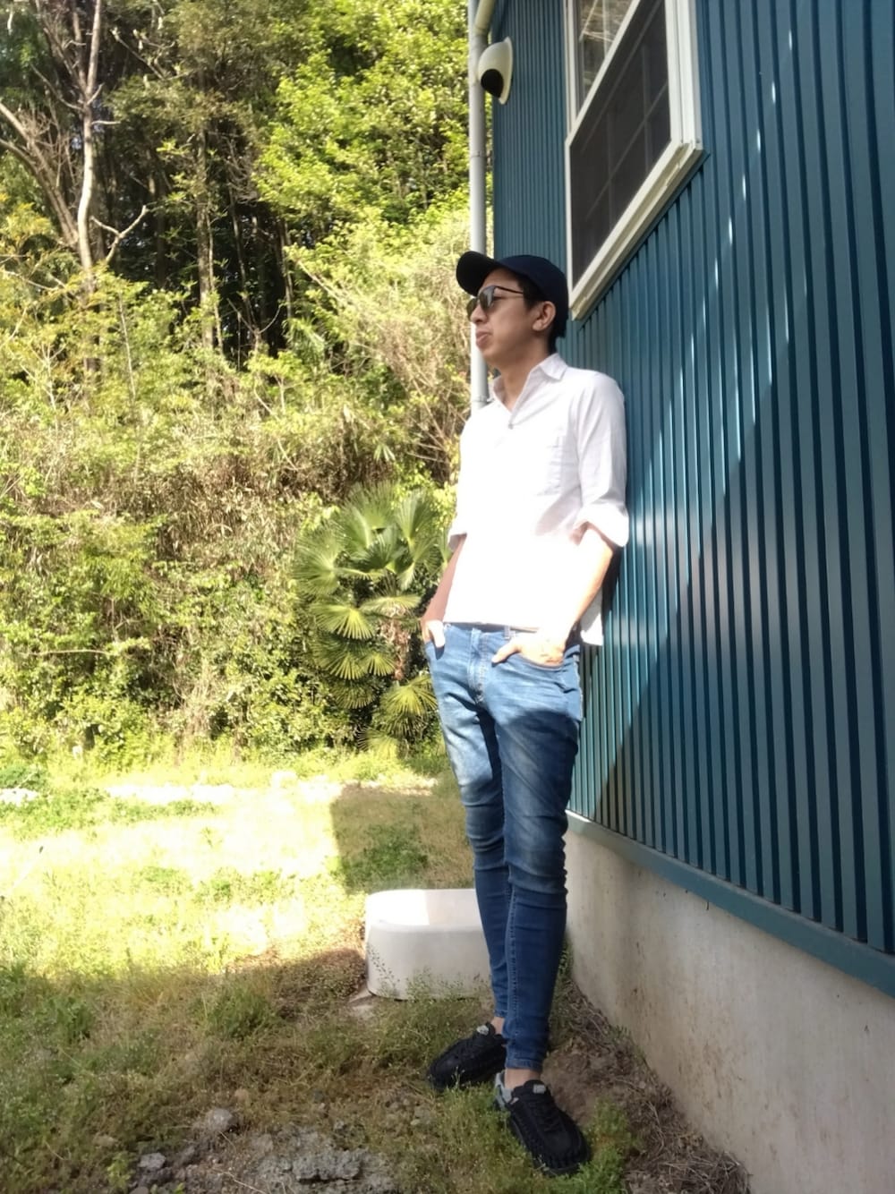 ブルー系のデニムパンツ、ホワイト系のシャツ/ブラウス、ブラック系のサンダルを着用したメンズの春コーディネートの1枚目の写真