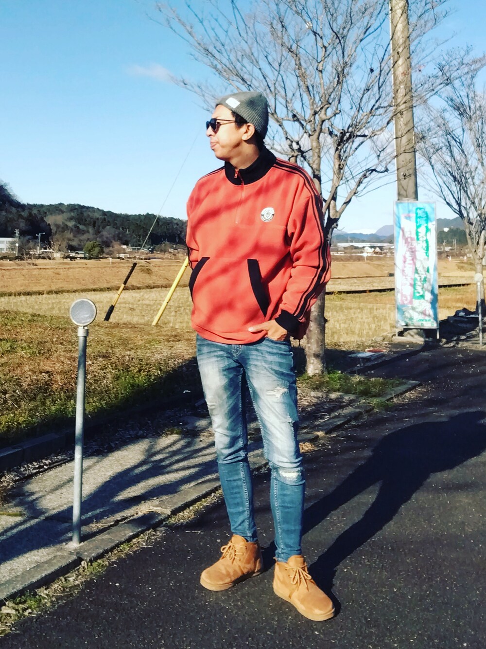 オレンジ系のスウェット、ブルー系のデニムパンツ、ブラウン系のブーツを着用したメンズの冬コーディネートの1枚目の写真