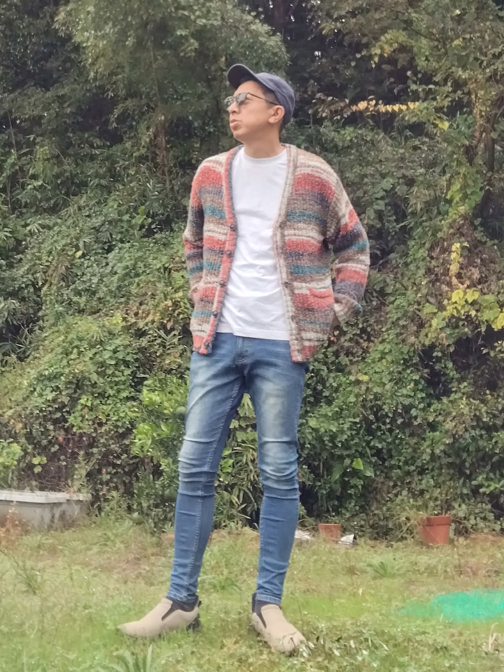 ホワイト系のTシャツ/カットソー、オレンジ系のカーディガン/ボレロ、ブルー系のデニムパンツを着用したメンズの秋コーディネートの1枚目の写真