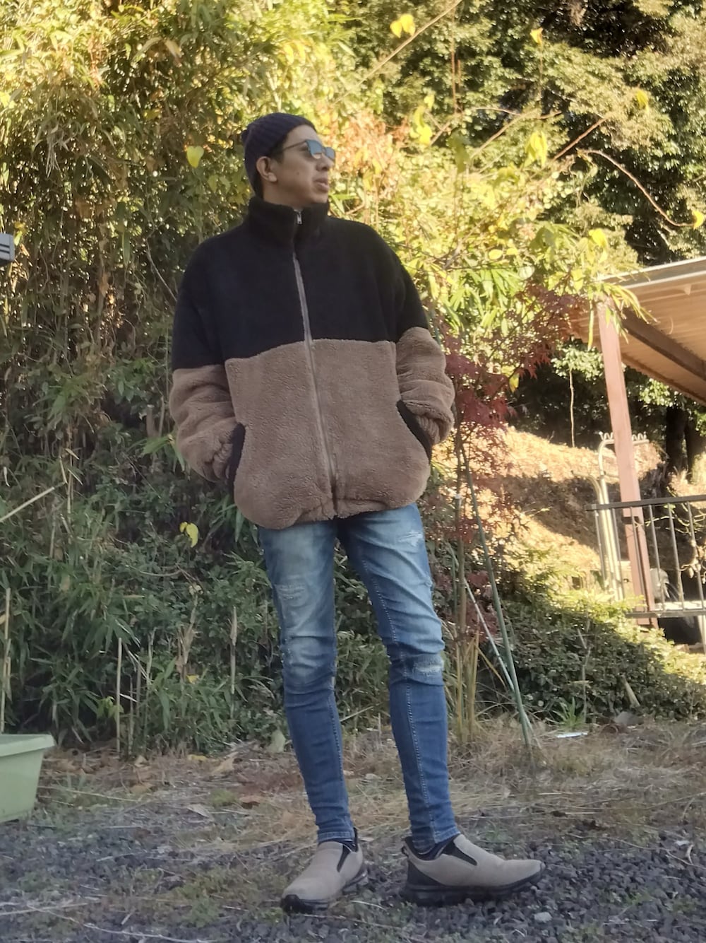 ブラック系のブルゾン、ブルー系のデニムパンツ、ベージュ系のスリッポンを着用したメンズの秋コーディネートの1枚目の写真