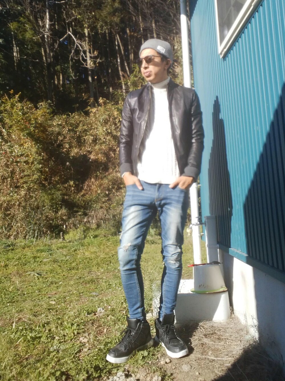 ホワイト系のニット/セーター、レッド系のシャツ/ブラウス、ブルー系のデニムパンツを着用したメンズの秋コーディネートの1枚目の写真