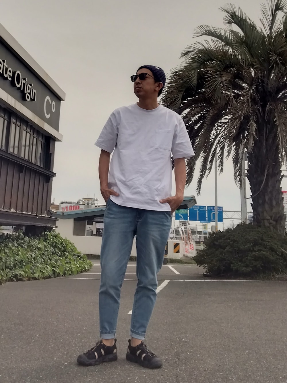 ホワイト系のTシャツ/カットソー、ブルー系のデニムパンツ、ブラック系のサンダルを着用したメンズの春コーディネートの1枚目の写真