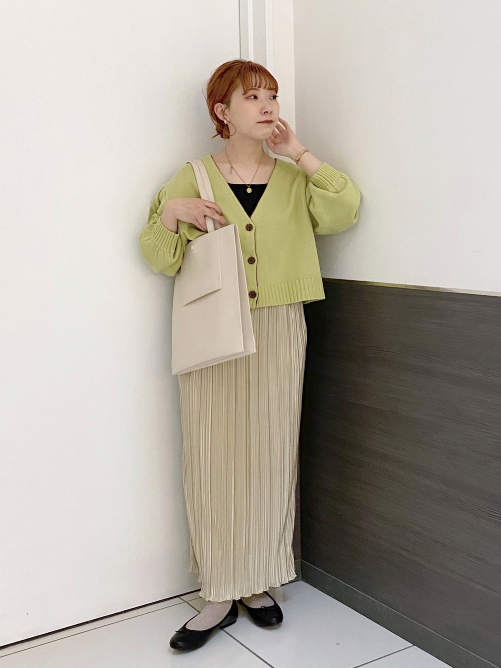 グリーン系のカーディガン/ボレロ、ホワイト系のスカート、ホワイト系のトートバッグを着用したレディースの春コーディネートの1枚目の写真