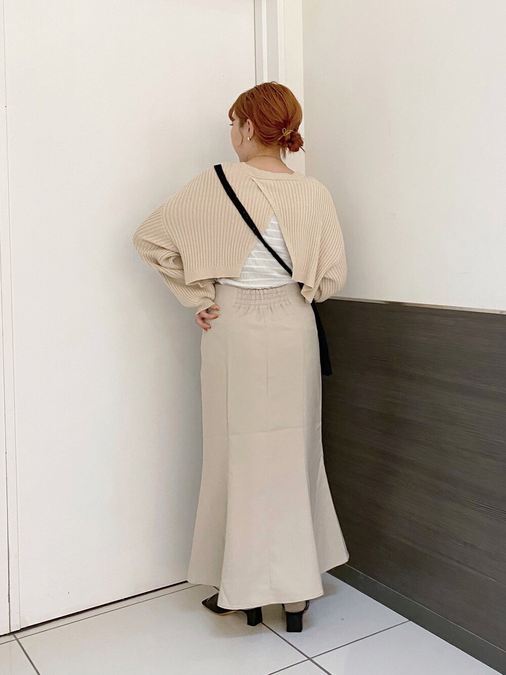 ホワイト系のスカート、ブラック系のサンダル、ブラック系のショルダーバッグを着用したレディースの春コーディネートの1枚目の写真