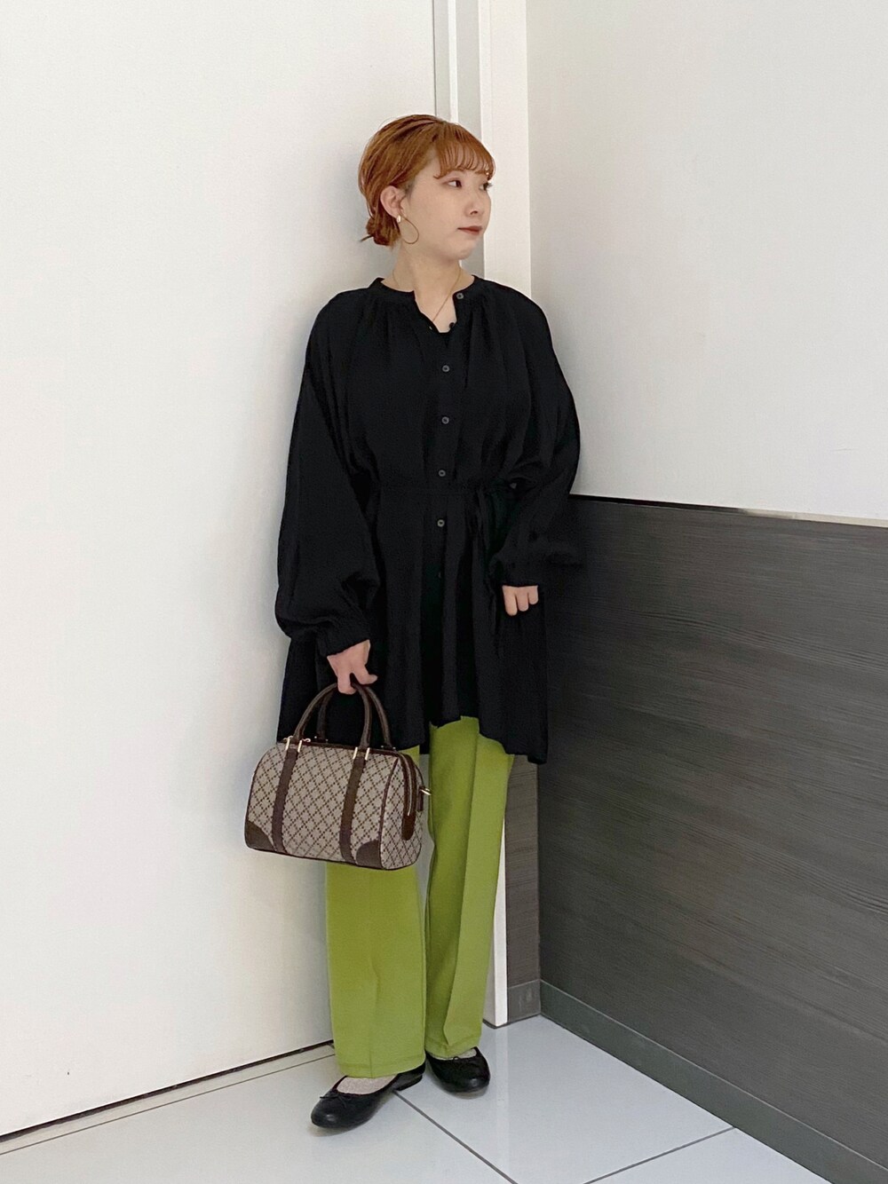 ブラック系のバレエシューズ、ブラウン系のボストンバッグ、グリーン系のその他パンツを着用したレディースの春コーディネートの1枚目の写真