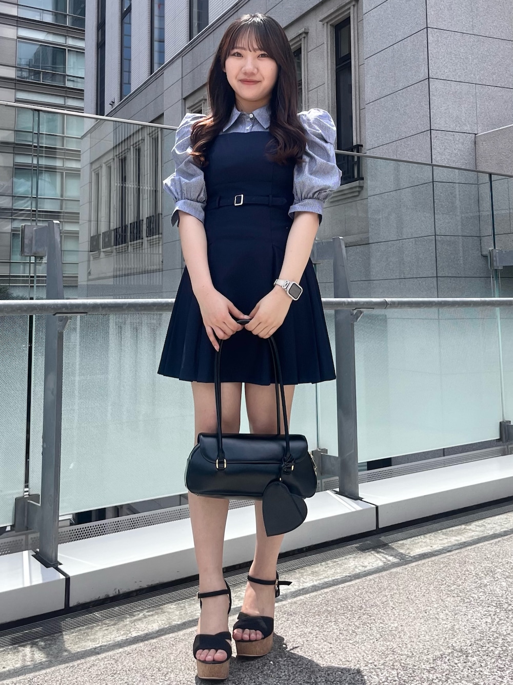 ブルー系のワンピース、ブラック系のハンドバッグ、ブラック系のサンダルを着用したレディースの夏コーディネートの1枚目の写真