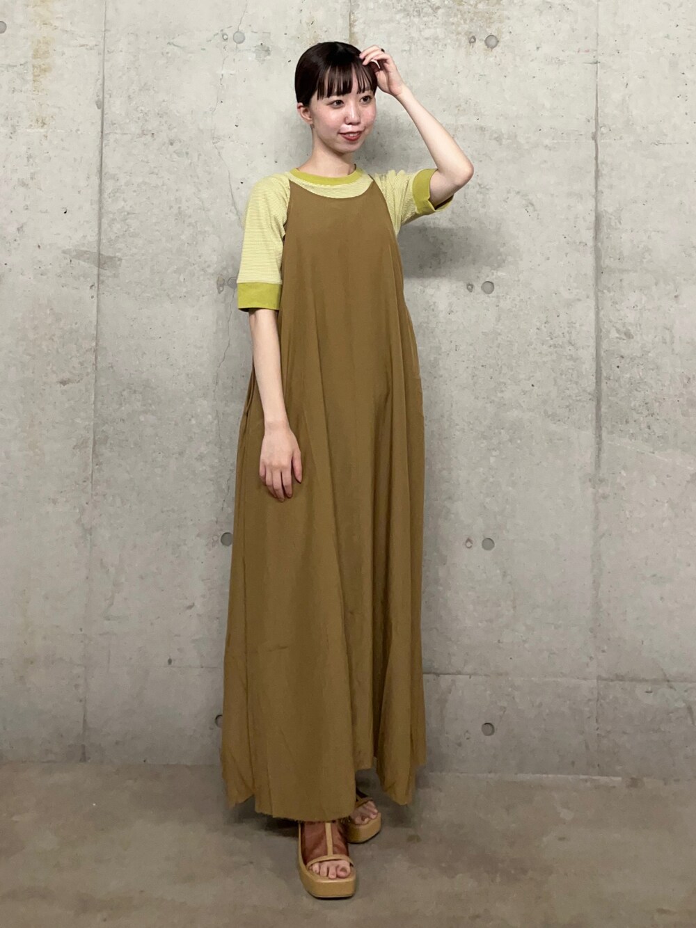 イエロー系のワンピース、グリーン系のTシャツ/カットソー、ベージュ系のサンダルを着用したレディースの夏コーディネートの1枚目の写真