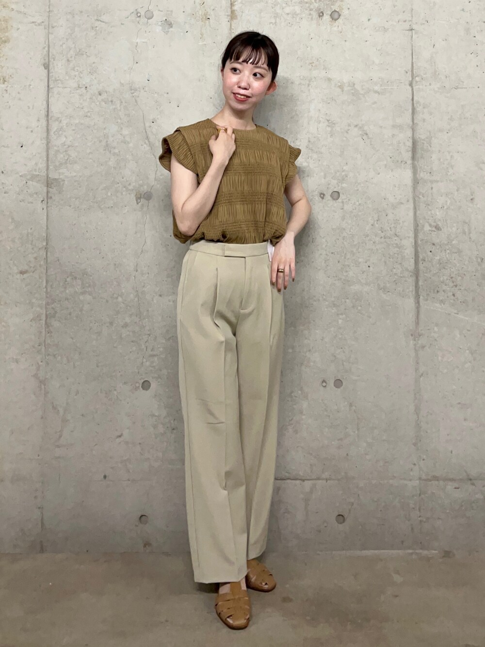 ベージュ系のスラックス、ベージュ系のサンダル、ベージュ系のシャツ/ブラウスを着用したレディースの夏コーディネートの1枚目の写真