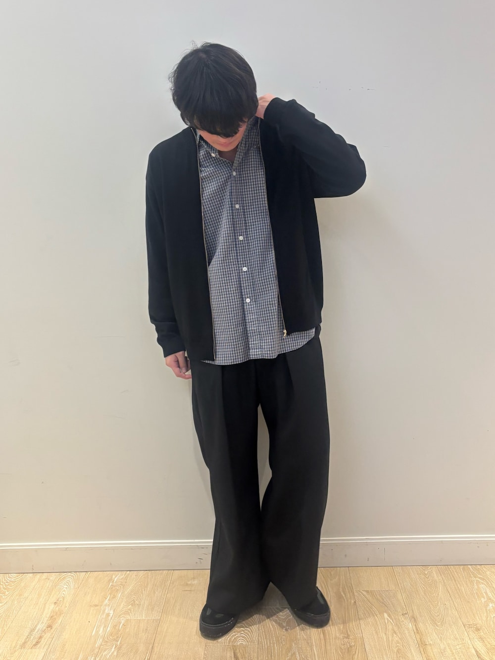 ブラック系のニット/セーター、ブルー系のシャツ/ブラウスを着用したメンズの秋コーディネートの1枚目の写真