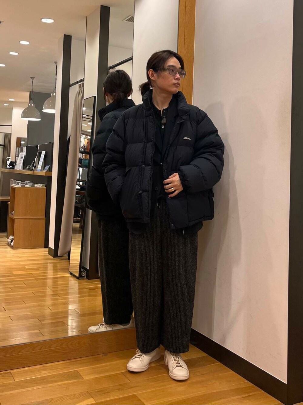 グレー系のその他パンツ、ブラック系のダウンジャケット/コート、グリーン系のニット/セーターを着用したメンズの冬コーディネートの1枚目の写真