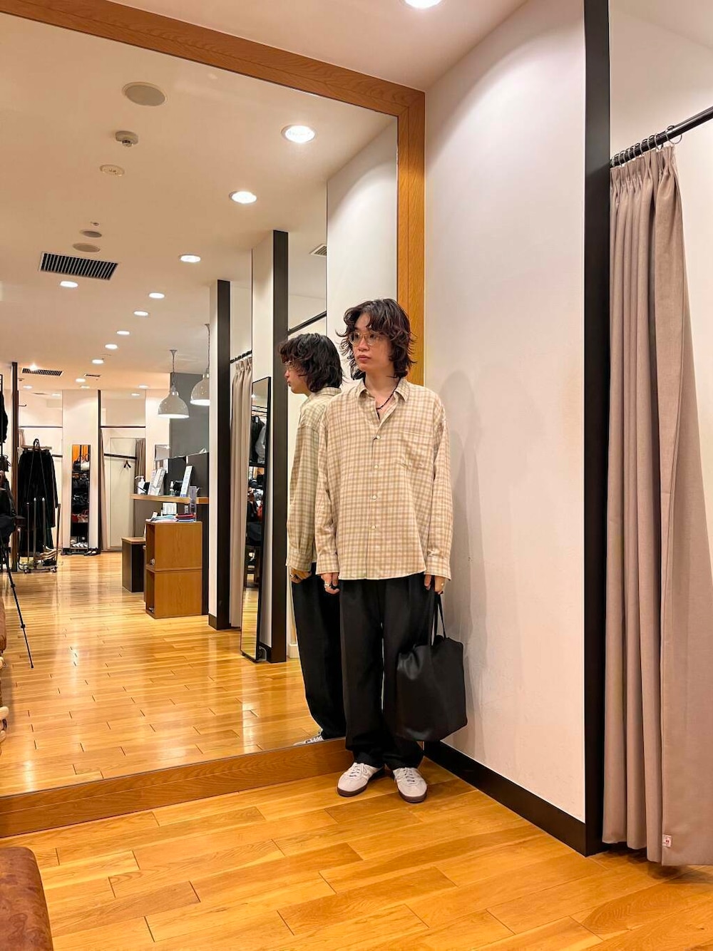 ベージュ系のシャツ/ブラウス、グレー系のスニーカー、ブラック系のトートバッグを着用したメンズの秋コーディネートの1枚目の写真