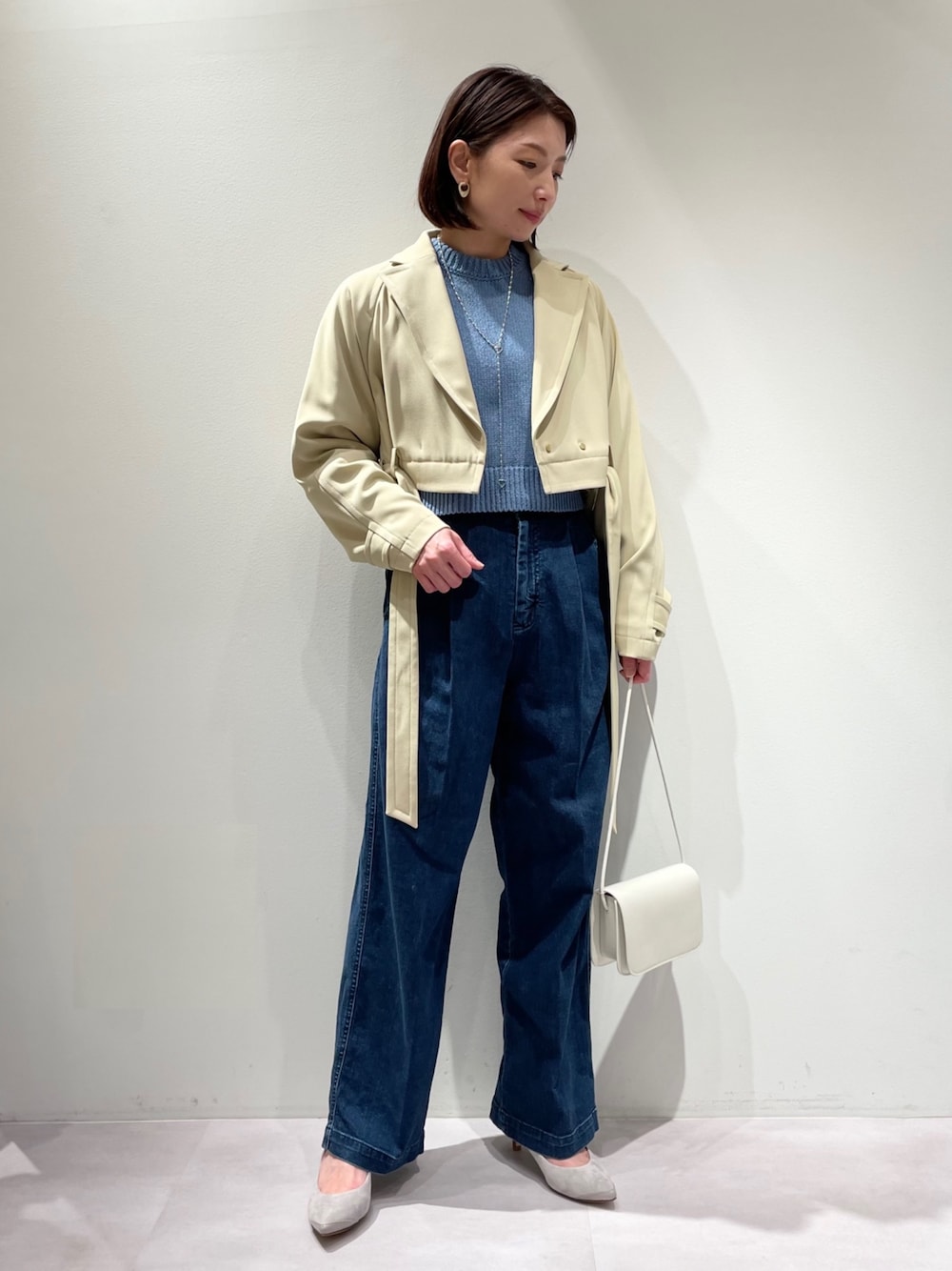 ブルー系のデニムパンツ、グレー系のパンプス、ブルー系のニット/セーターを着用したレディースの冬コーディネートの1枚目の写真