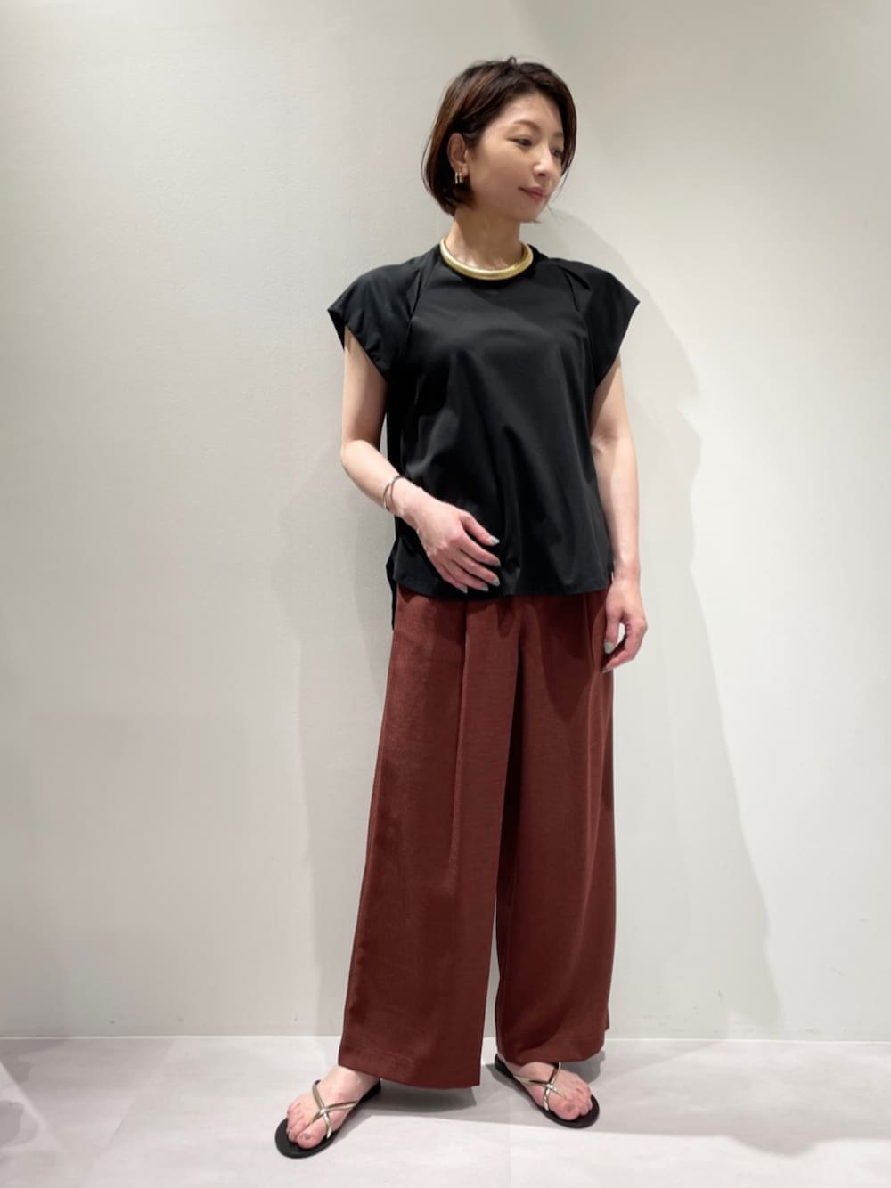 ブラック系のTシャツ/カットソー、レッド系のその他パンツ、ゴールド系のサンダルを着用したレディースの夏コーディネートの1枚目の写真