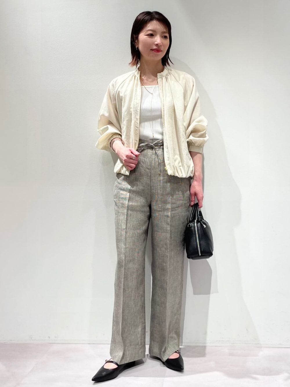 ホワイト系のタンクトップ、ホワイト系のブルゾン、ベージュ系のその他パンツを着用したレディースの春コーディネートの1枚目の写真