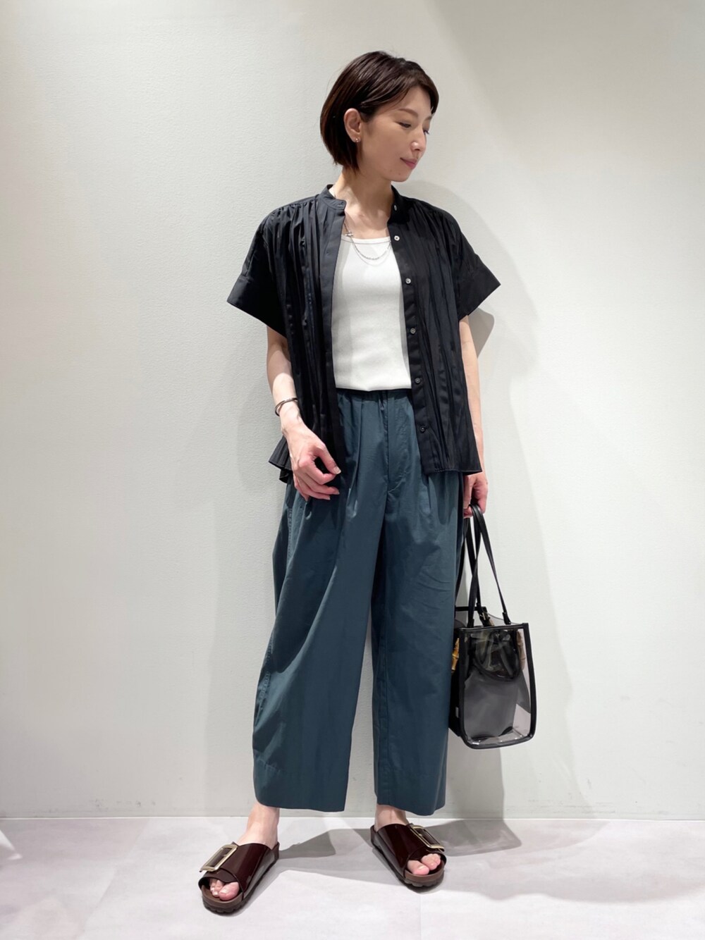 ホワイト系のタンクトップ、ブラック系のシャツ/ブラウス、グリーン系のその他パンツを着用したレディースの夏コーディネートの1枚目の写真