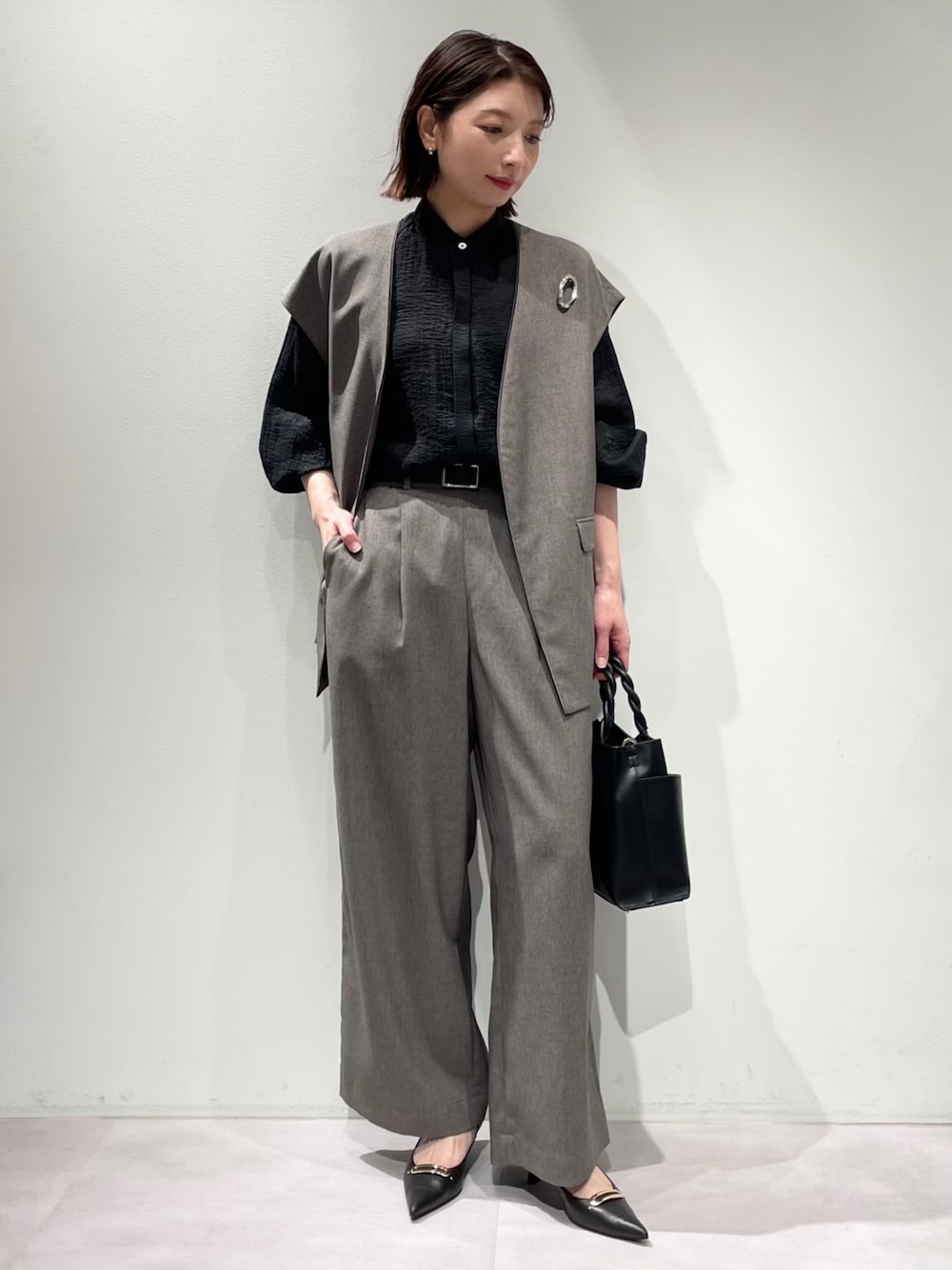 グレー系のその他パンツ、グレー系のベスト、ブラック系のシャツ/ブラウスを着用したレディースの秋コーディネートの1枚目の写真