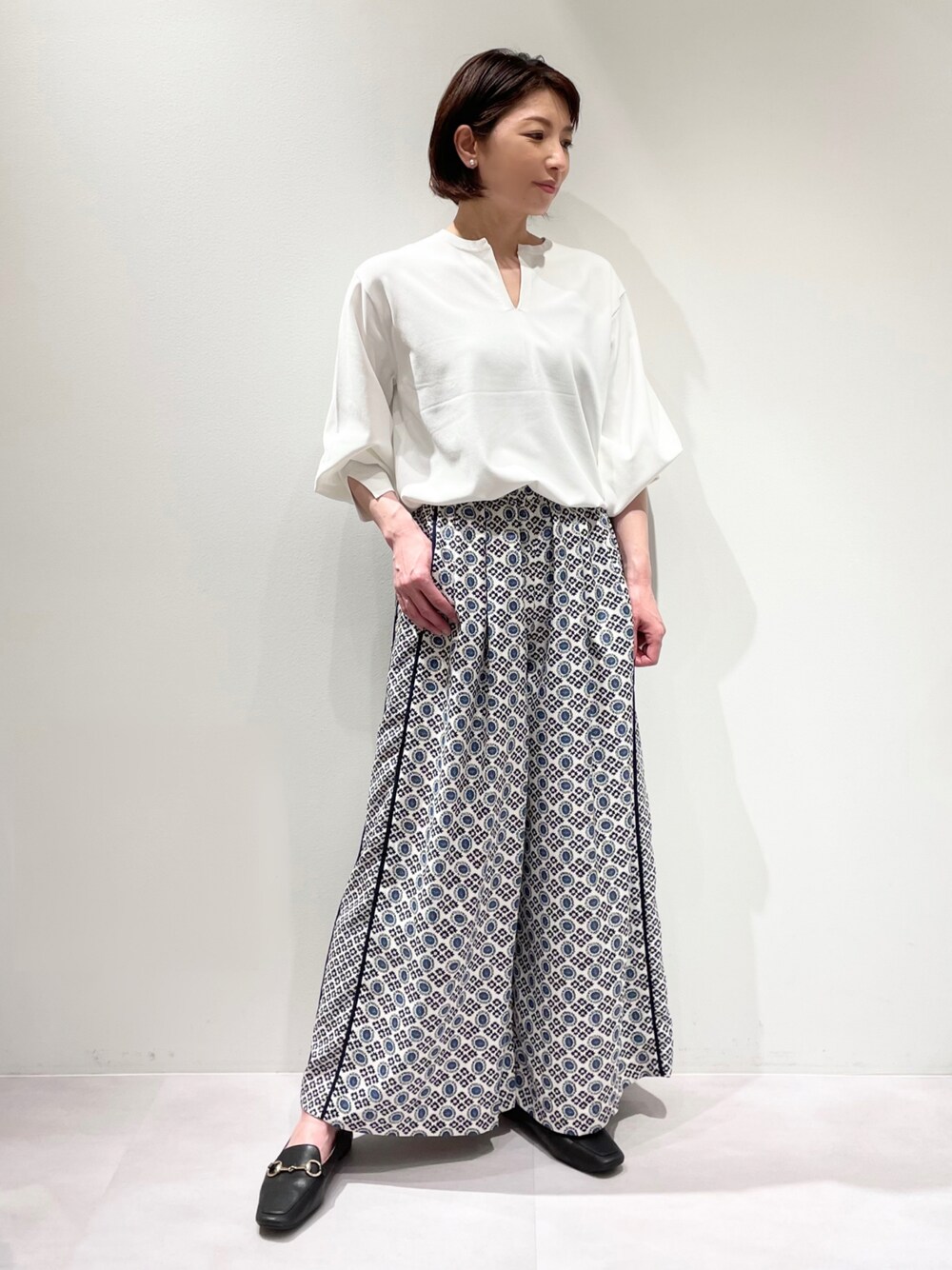 ホワイト系のニット/セーター、ブルー系のその他パンツ、ブラック系のローファーを着用したレディースの冬コーディネートの1枚目の写真