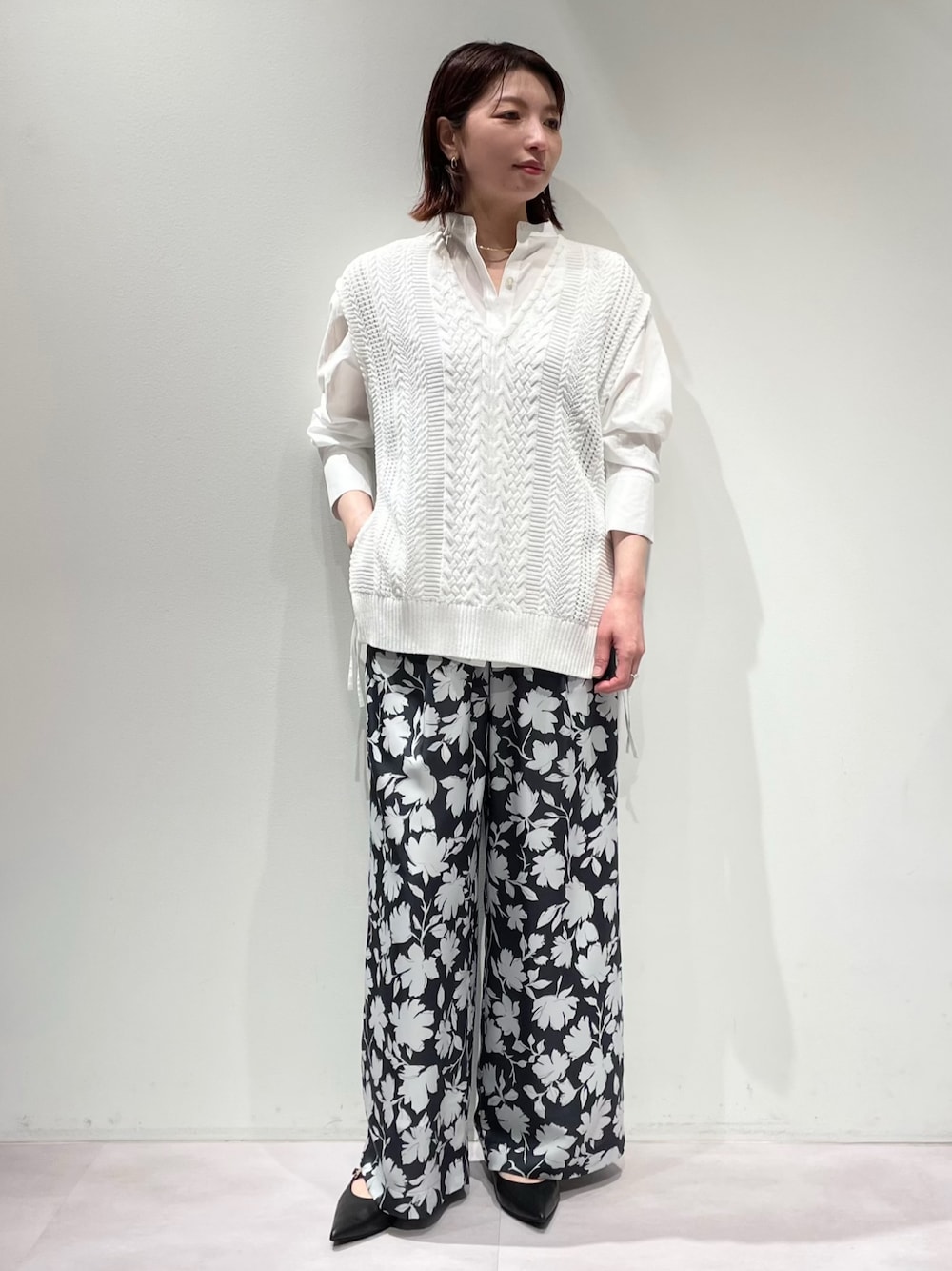 グレー系のその他パンツ、ホワイト系のニット/セーター、ゴールド系のネックレスを着用したレディースの冬コーディネートの1枚目の写真