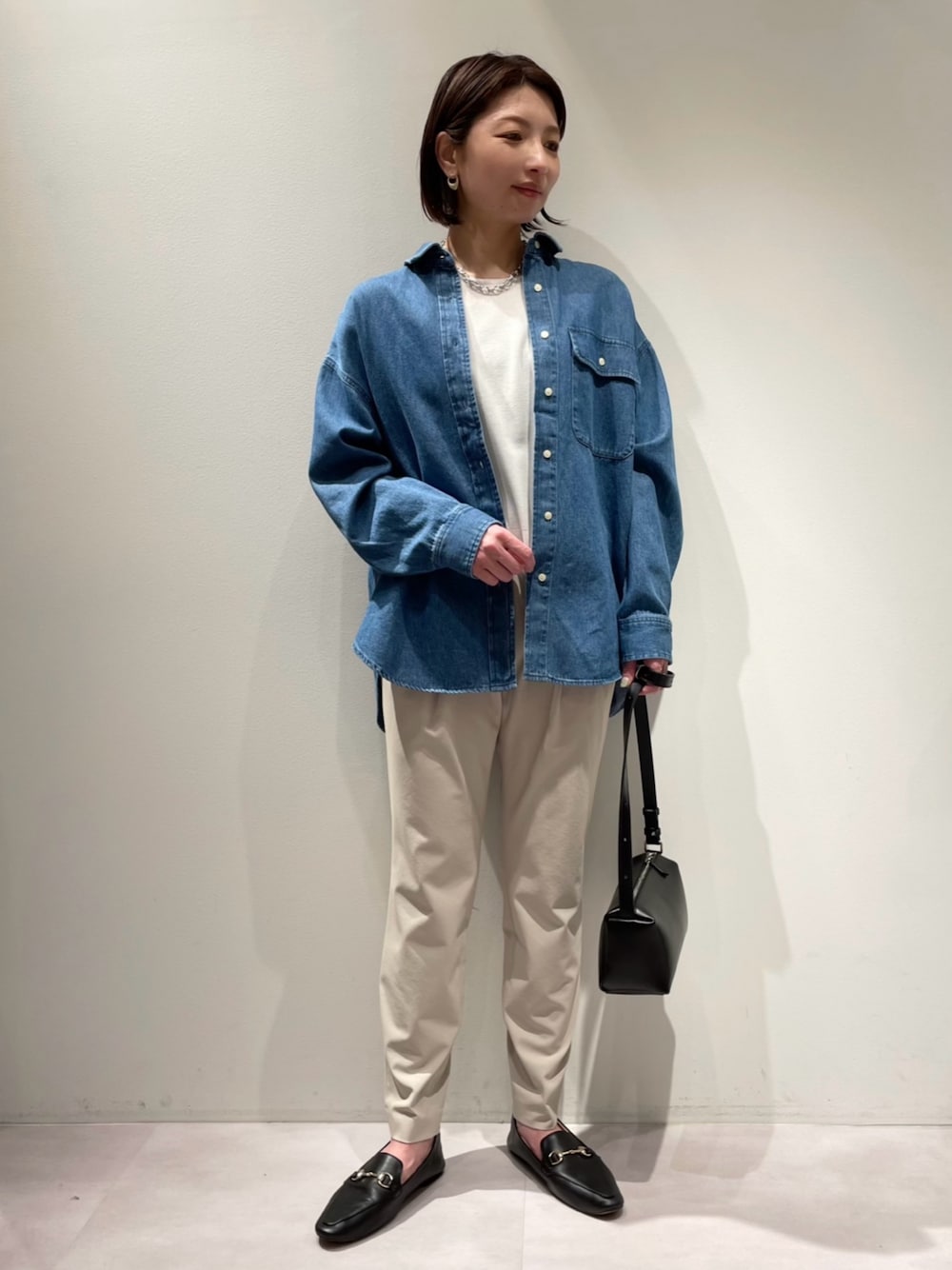 「カリテ(qualite)、カリテスケープ、お出かけコーデ、デニムシャツ、ハイゲージニット、春ニット、タックパンツ、テーパードパンツ ベージュ、テーパードパンツ、大人カジュアル、春コーデ、ウエストゴム、ストレスフリー、パンツスタイル、休日スタイル」｜「qualite scapeのミドルオンスデニムシャツ（シャツ/ブラウス、ブルー系）」を使った、KAWAMURAさん（レディース・160cm）の春コーディネートの1枚目の写真