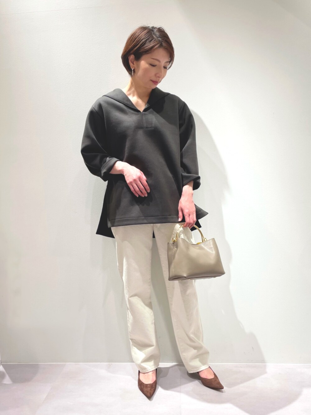 グレー系のTシャツ/カットソー、ホワイト系のデニムパンツを着用したレディースの冬コーディネートの1枚目の写真